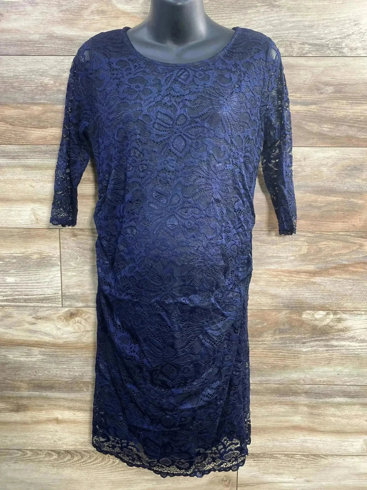 Front view of navy Pink Blush maternity lace dress, size L, showing fitted silhouette, 3/4 sleeves, scalloped hem on wood background