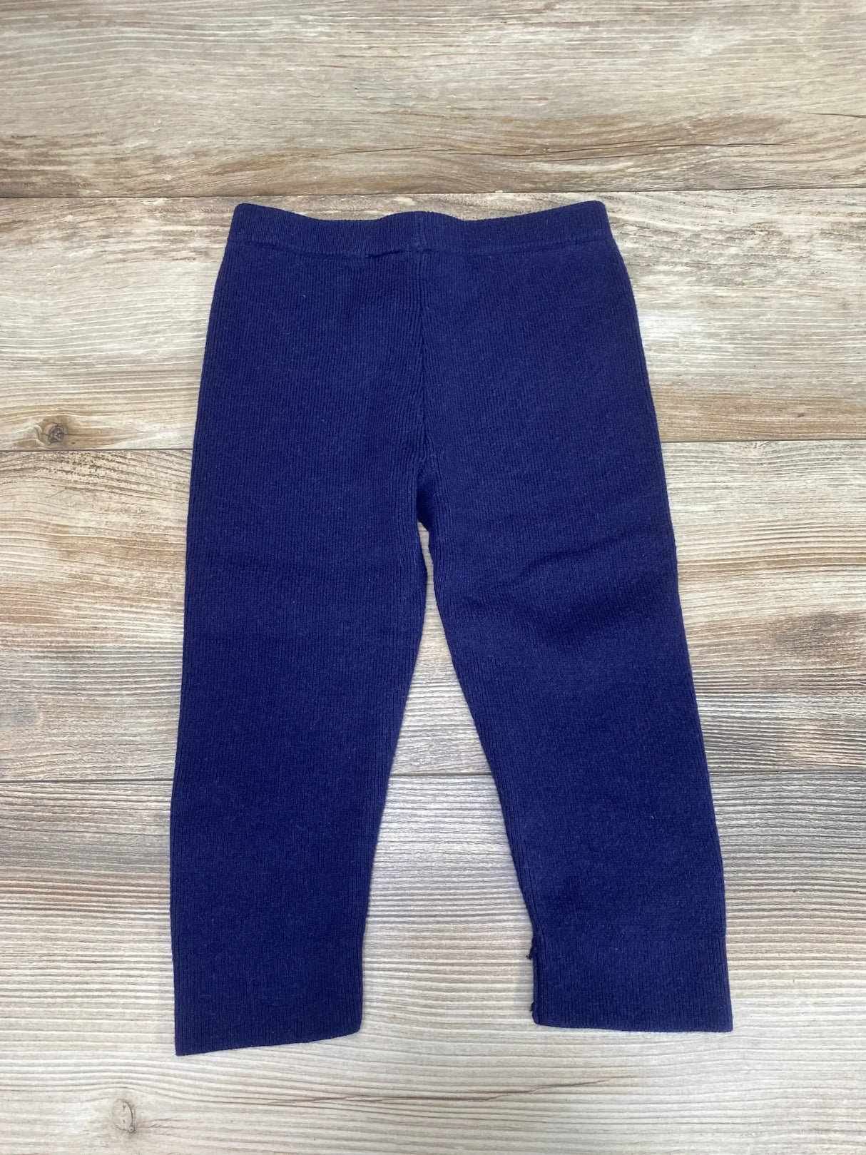 Front flat lay of Janie and Jack navy sweater pants showcasing elastic waistband, ribbed knit texture and straight legs on wood background