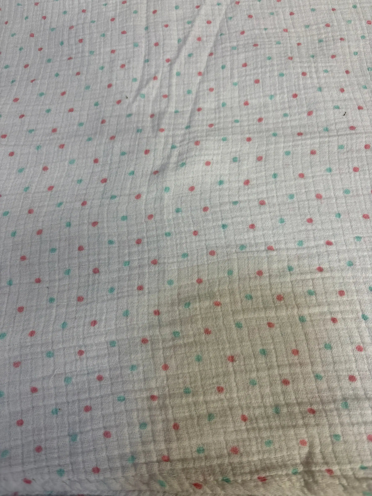 Soft polka dot baby blanket with red and teal dots on white fabric, ideal for newborns and toddlers.