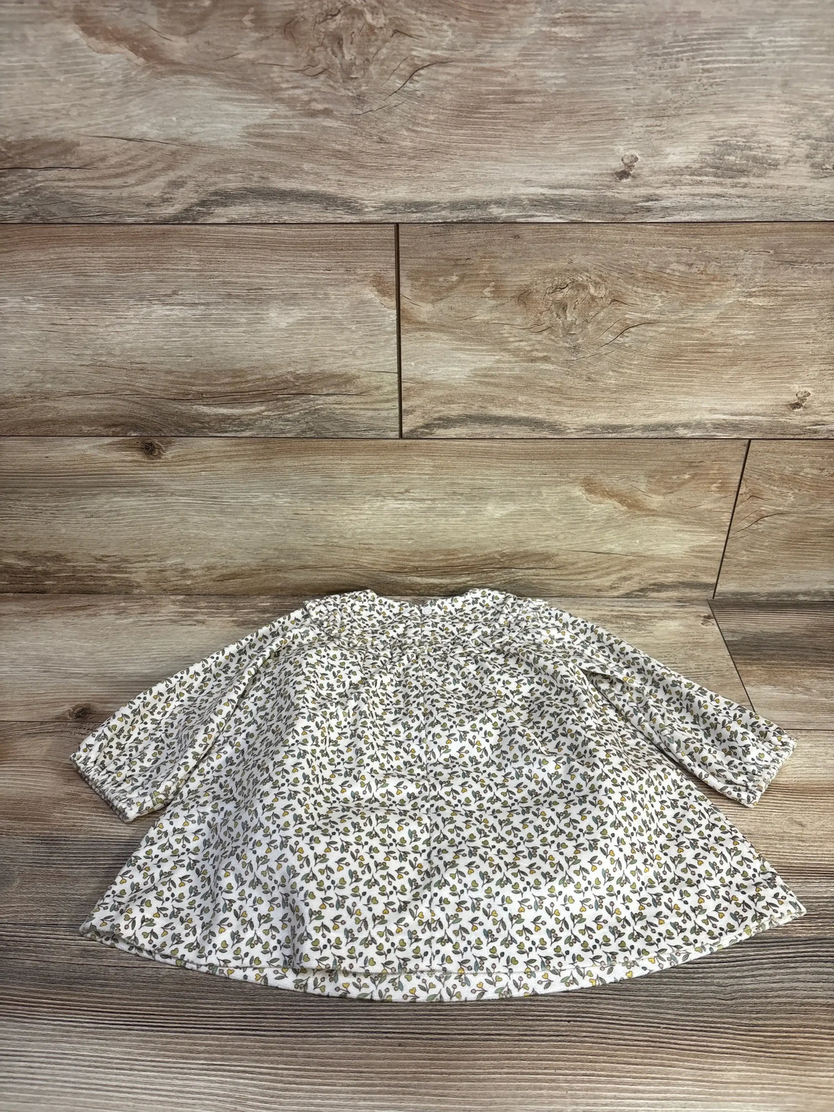 Front view of Mayoral Floral Long Sleeve Velvet Dress in cream showcasing tiny brown floral print long sleeves and flared a-line hem on wood plank floor