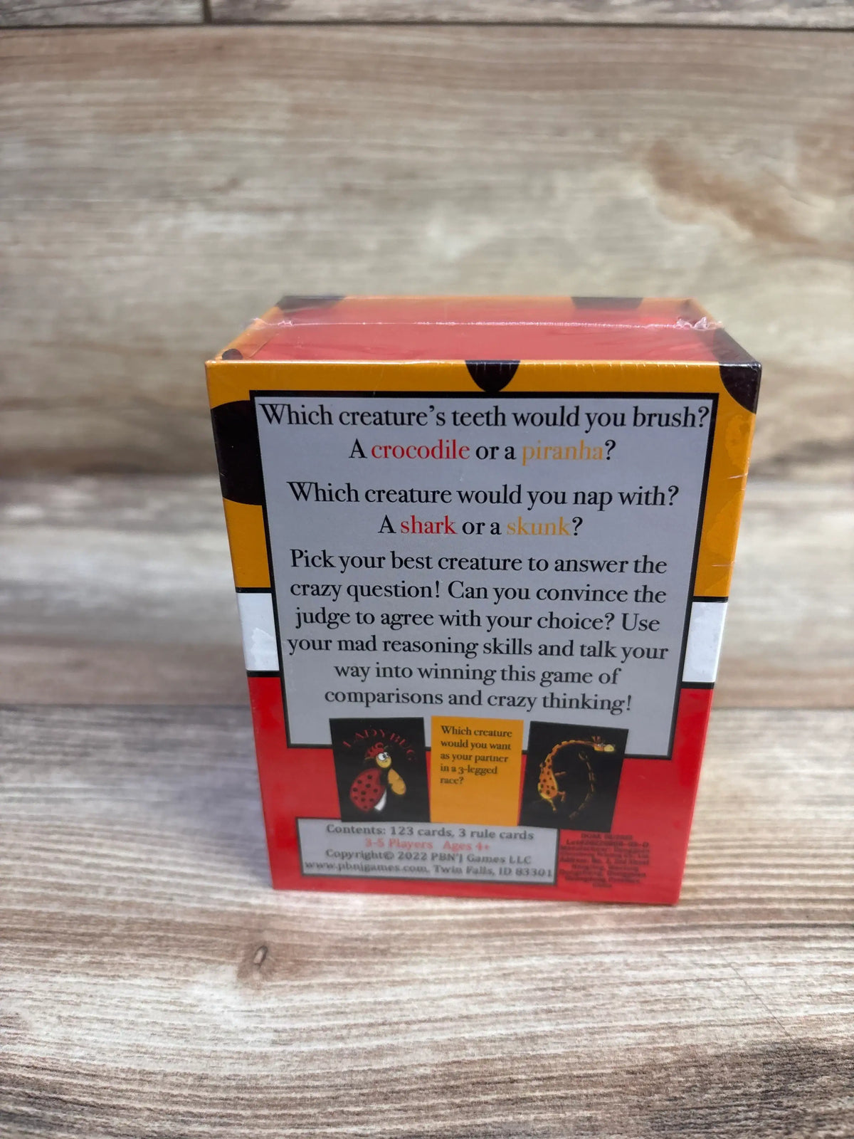 Back of Chicken or Cheetah card game box with description and sample questions: crocodile or piranha; shark or skunk