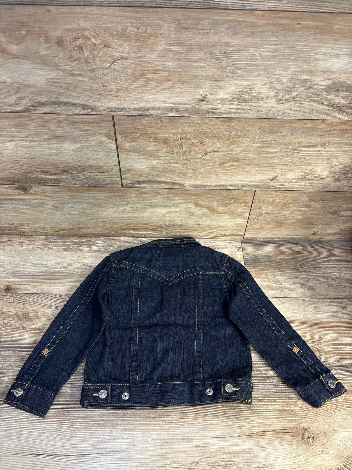 Back view of NEW True Religion Jimmy Western Denim Jacket in blue, showcasing western yoke detailing on a wood plank background
