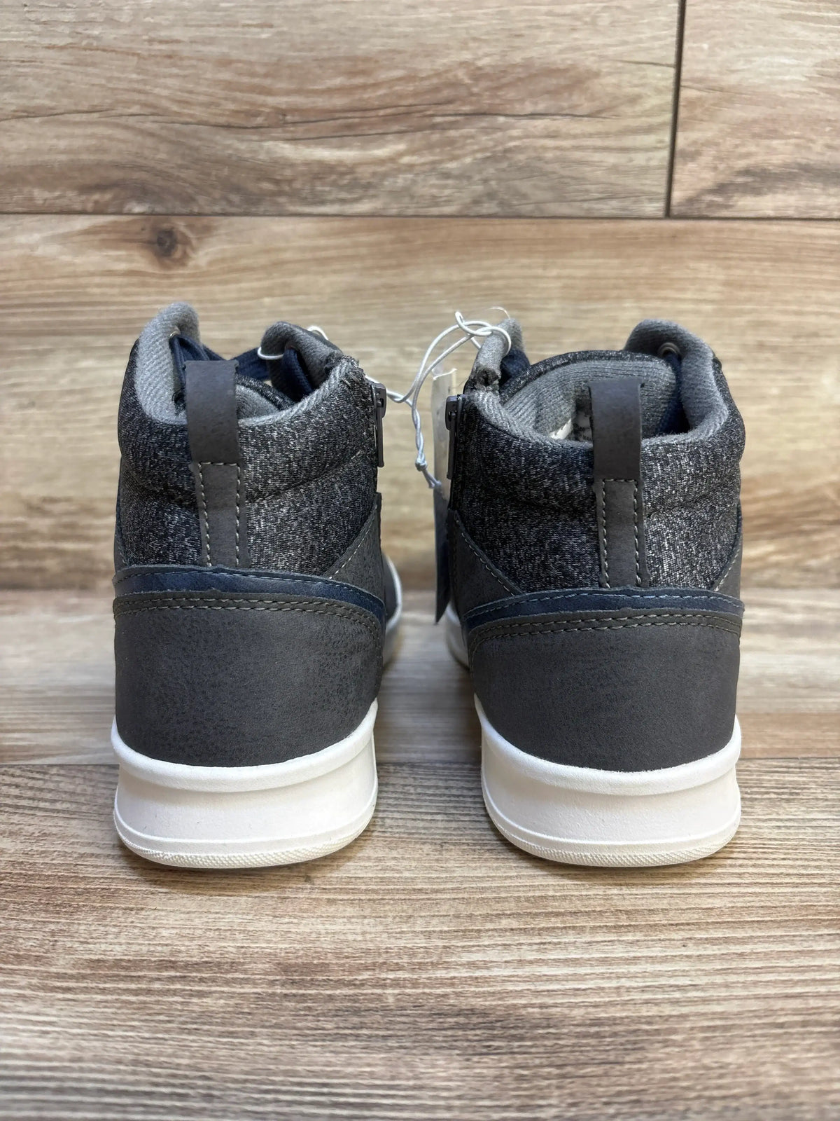 Rear view of Art Class Geoff high-top sneakers size 4Y showing knit ankle collar, heel pull tab, and white soles on wood floor
