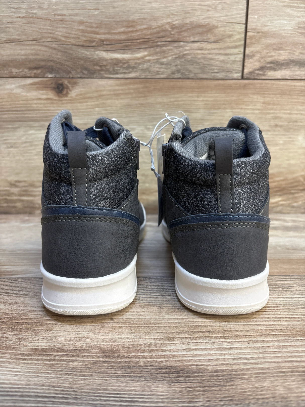 Rear view of Art Class Geoff high-top sneakers size 4Y showing knit ankle collar, heel pull tab, and white soles on wood floor