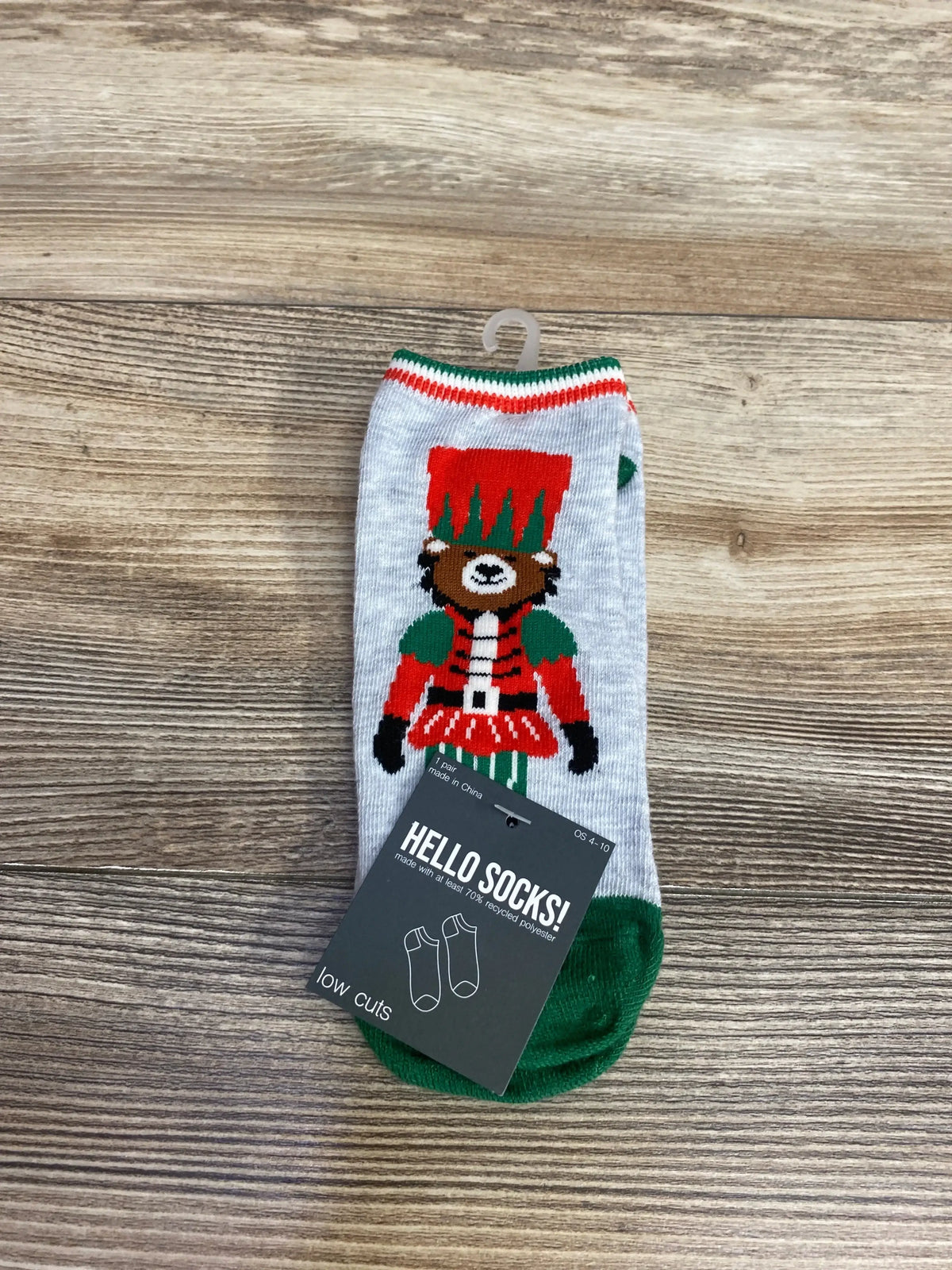 Low cut Hello Socks featuring a bear dressed as a red and green toy soldier on wooden floor
