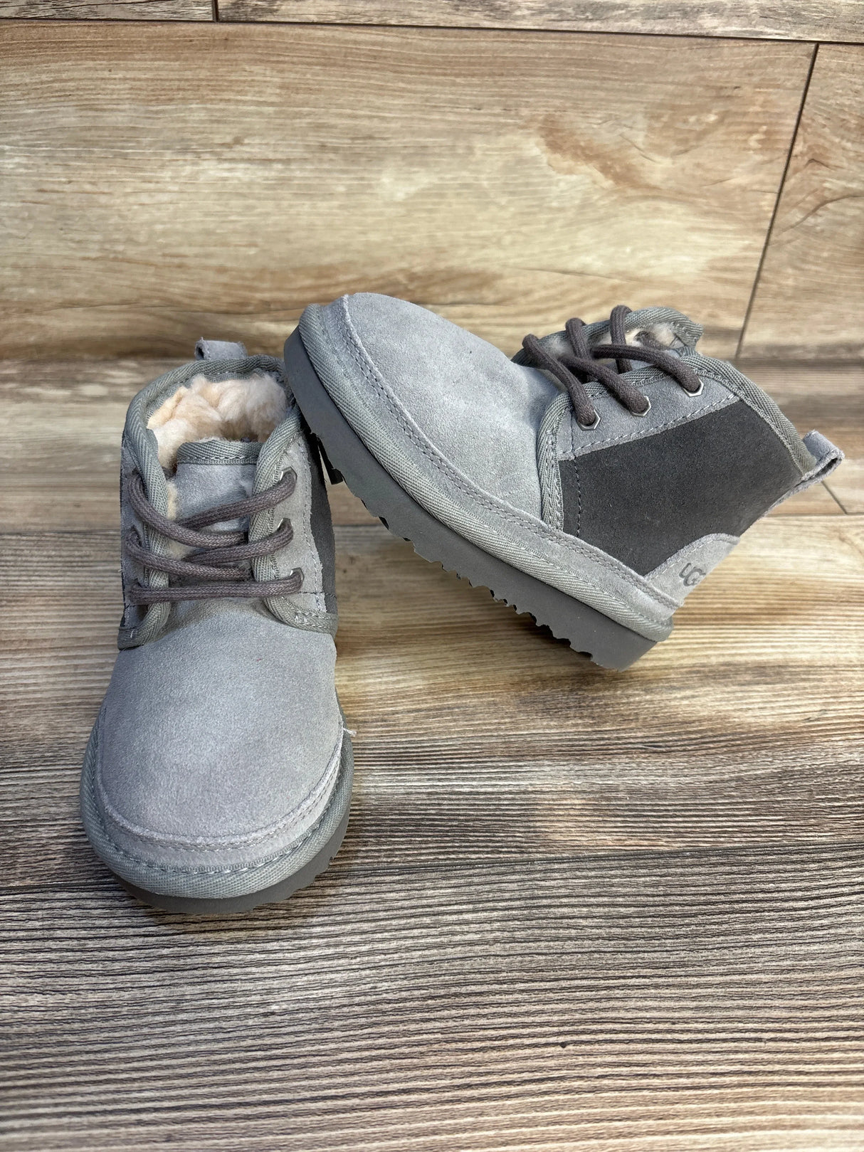 Gray suede toddler boots with faux fur lining on wood background