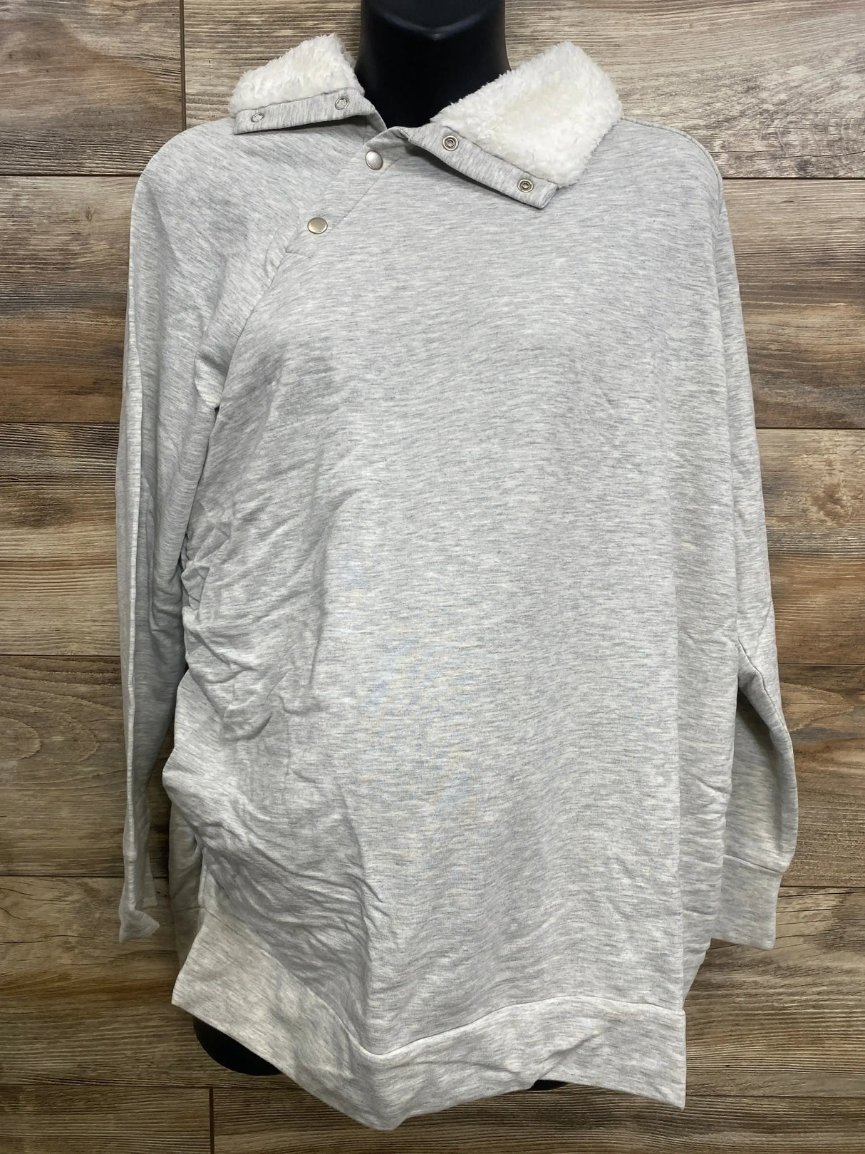 Front view of Isabel maternity grey sweatshirt showcasing sherpa snap collar, side ruching and long sleeves with wood background