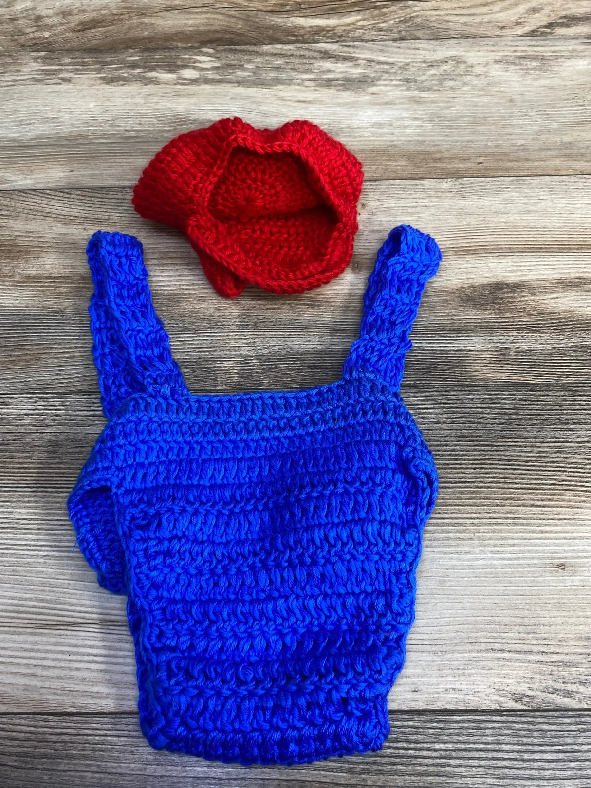 Hand-knit blue baby overalls with red hat, perfect for infant outfits and cozy baby gear.