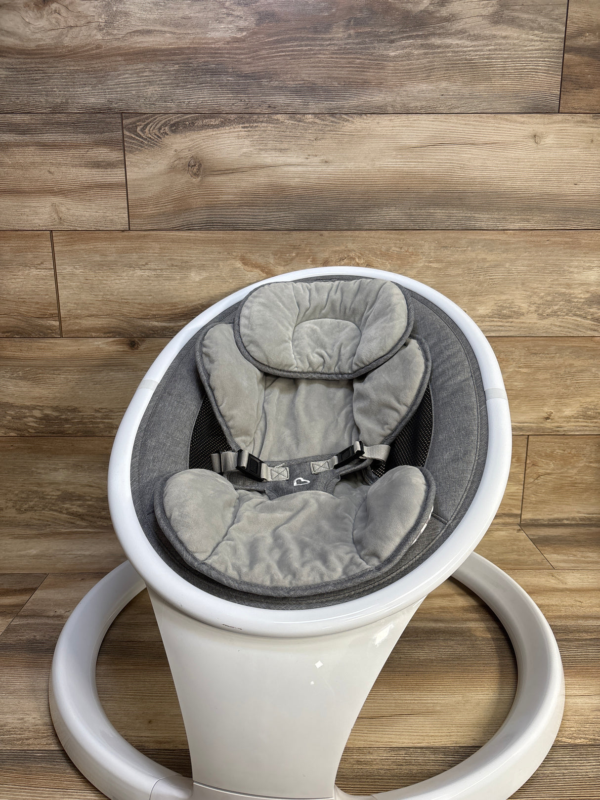 Front view of Munchkin Bluetooth Enabled Baby Swing showing gray padded seat and harness on white circular base