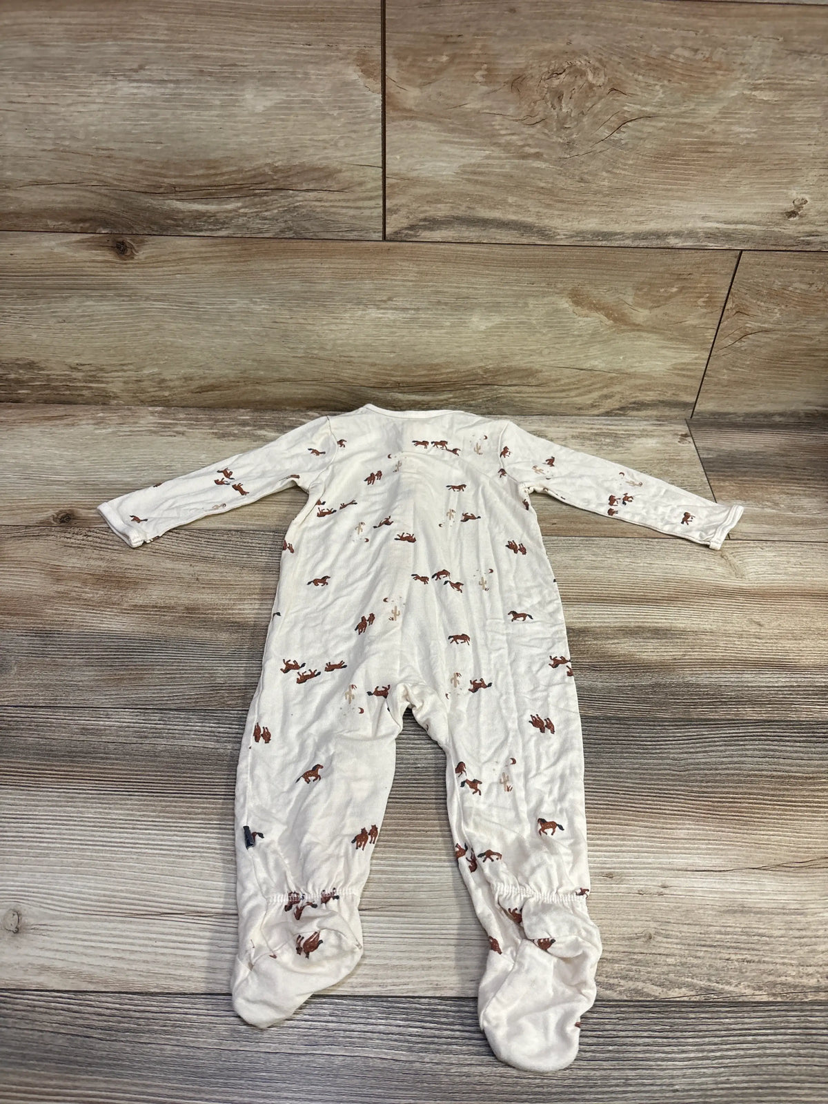 Front view of ivory Modern Moments horse print viscose sleeper with long sleeves and footed legs on a wood floor