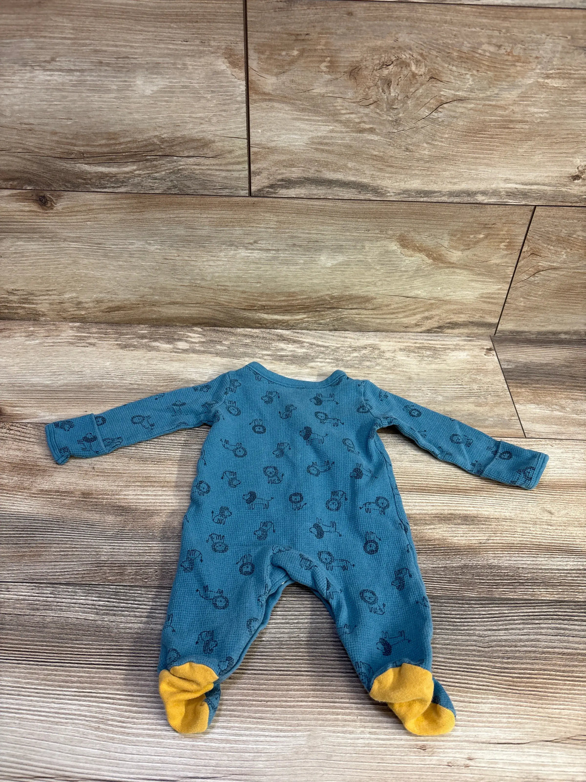 Carter's blue waffle knit newborn sleeper with animal print and yellow feet on wood background
