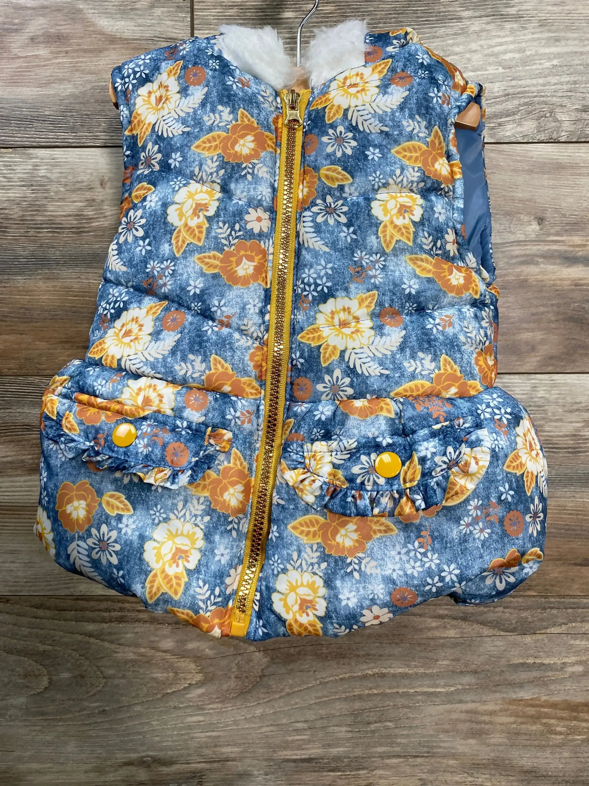 Front view of Little Lass puffer vest (blue, size 4T) with floral print, gold zipper, faux-fur hood and snap pockets