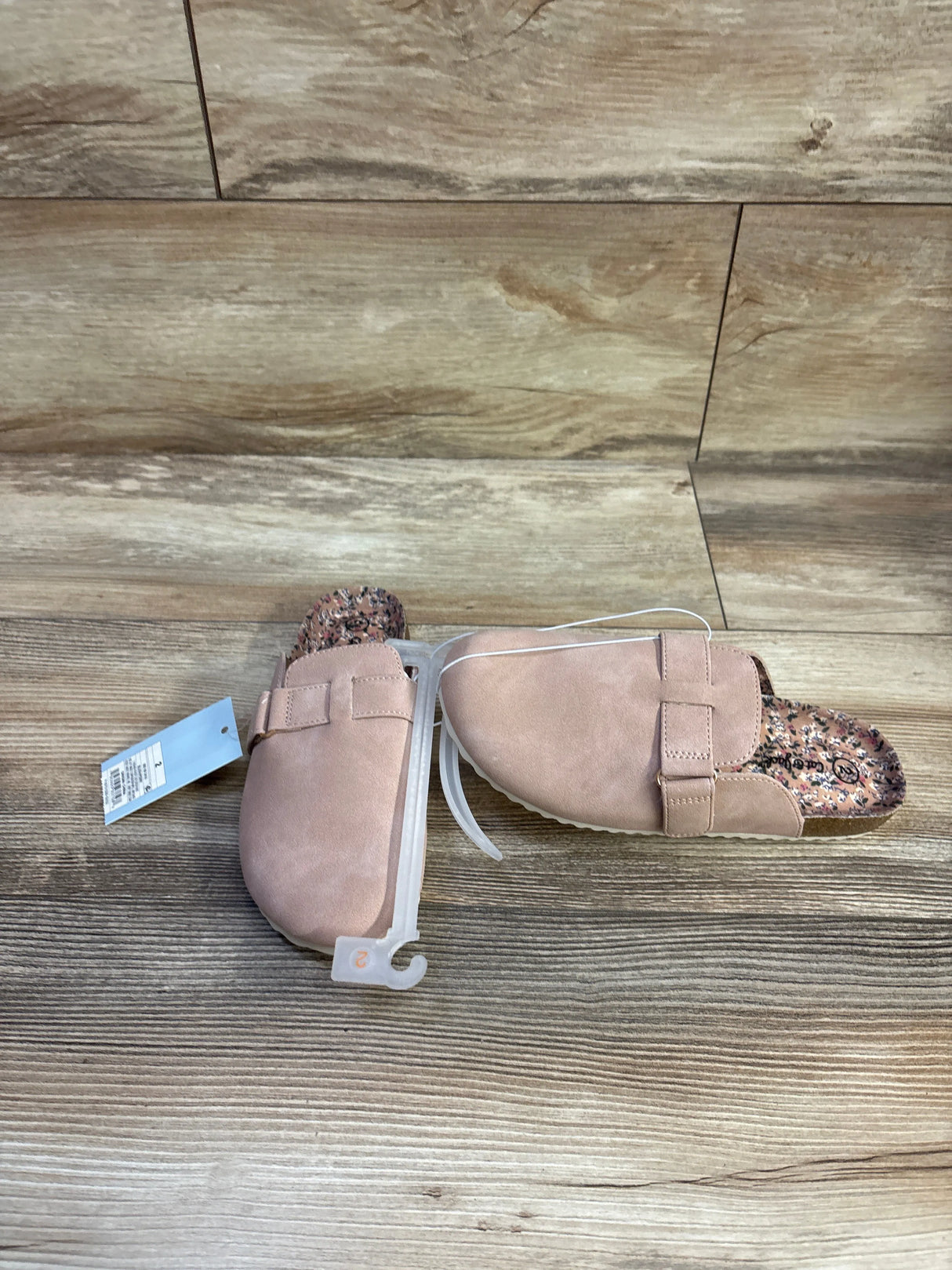 Top down view of Cat & Jack Perry toddler clogs in blush showcasing floral-print footbed, adjustable top strap and retail tag on wood floor