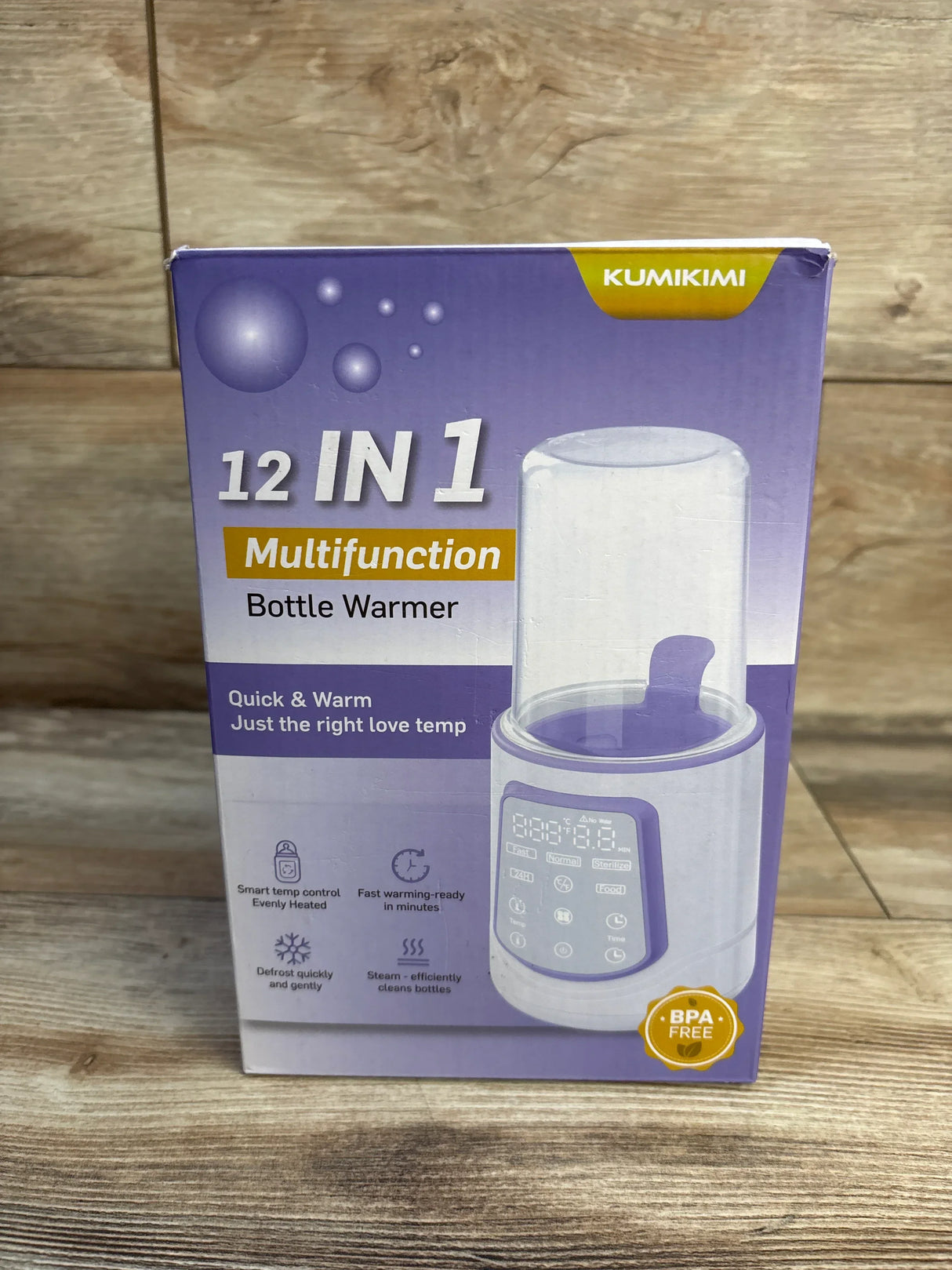 Front view of Kumikimi 12-in-1 bottle warmer box with digital display and BPA free badge on wood