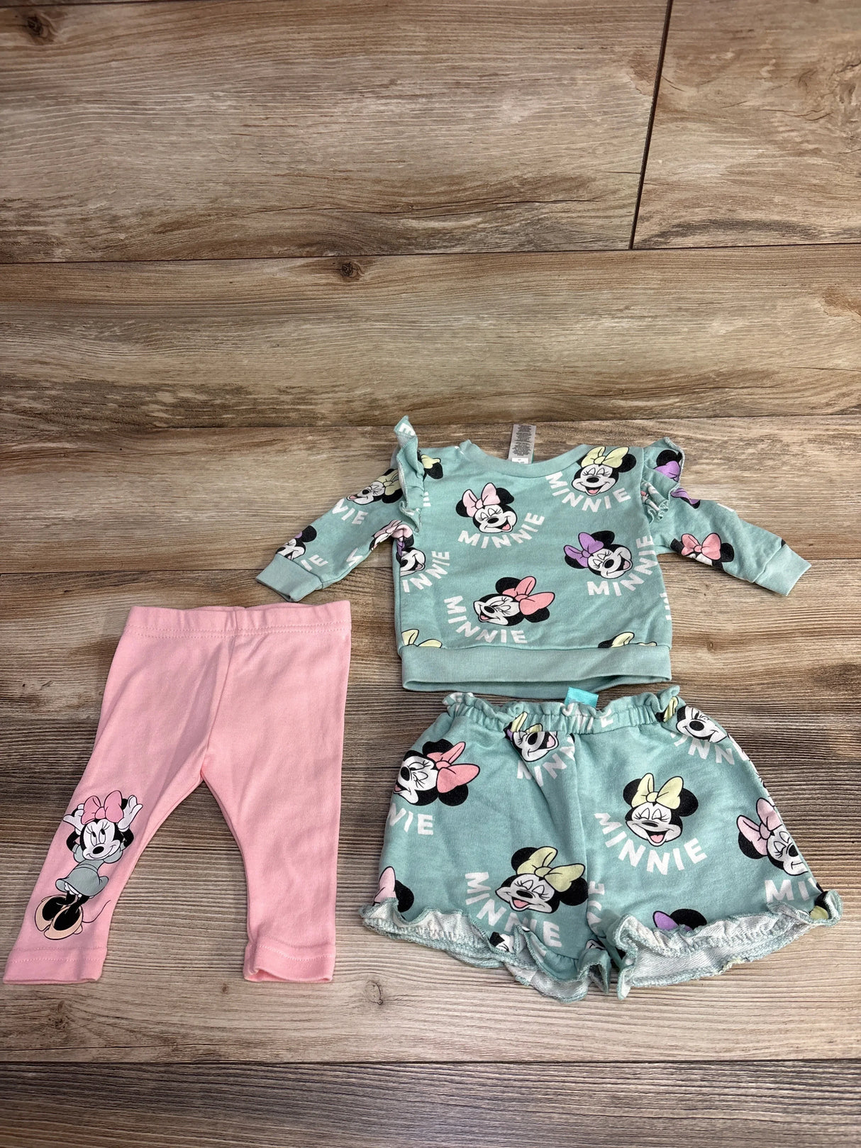 Children's clothing set with teal Minnie Mouse print sweatshirt and shorts, plus pink leggings featuring Minnie Mouse