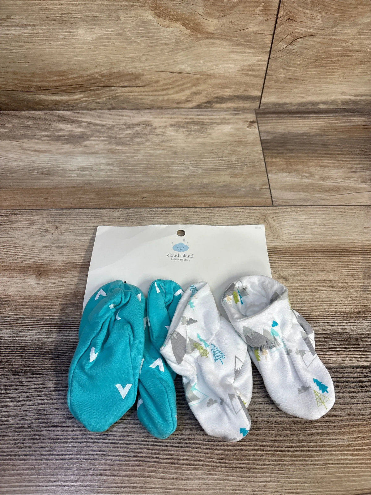 Top view of NEW Cloud Island 2pk Booties OSFM showcasing turquoise and white patterned cotton booties on a wood floor