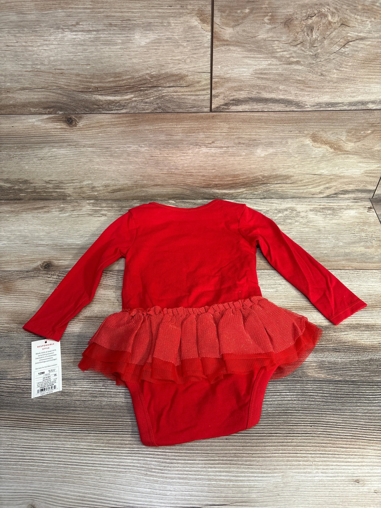 Red long sleeve baby onesie with tutu skirt, size 12M, on wood background