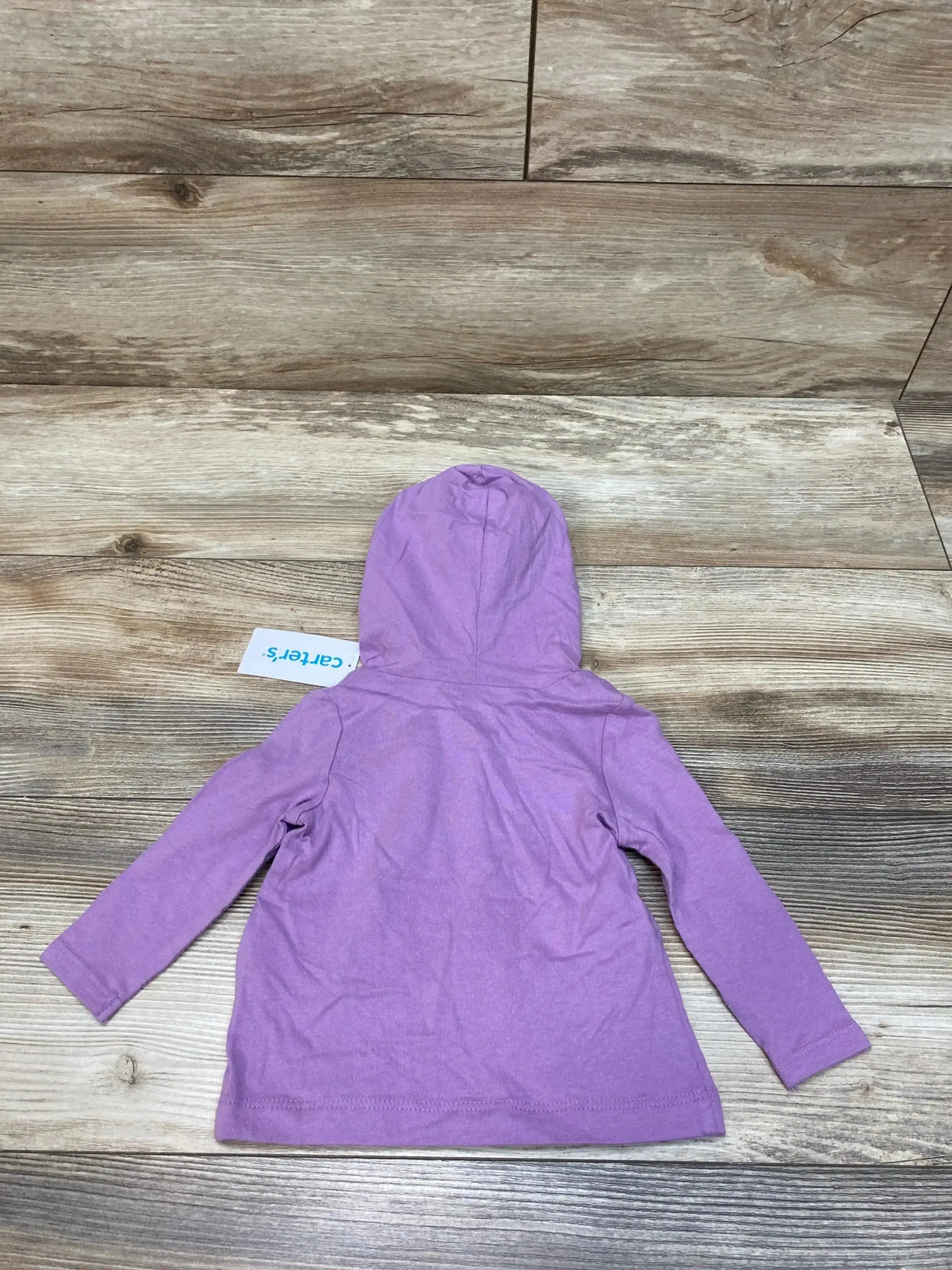 Back view of purple Carter's hooded baby shirt size 6M showing hood and long sleeves on wood floor background