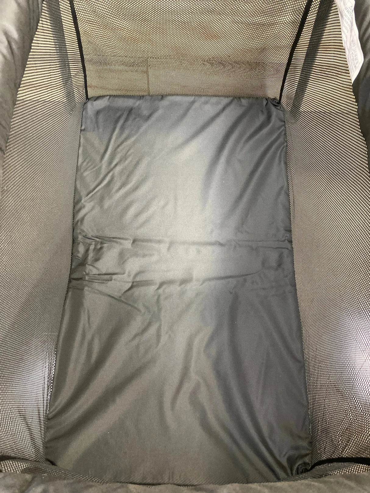 Top-down view of Dream On Me Travel Light playard interior showing black padded mattress and mesh side panels