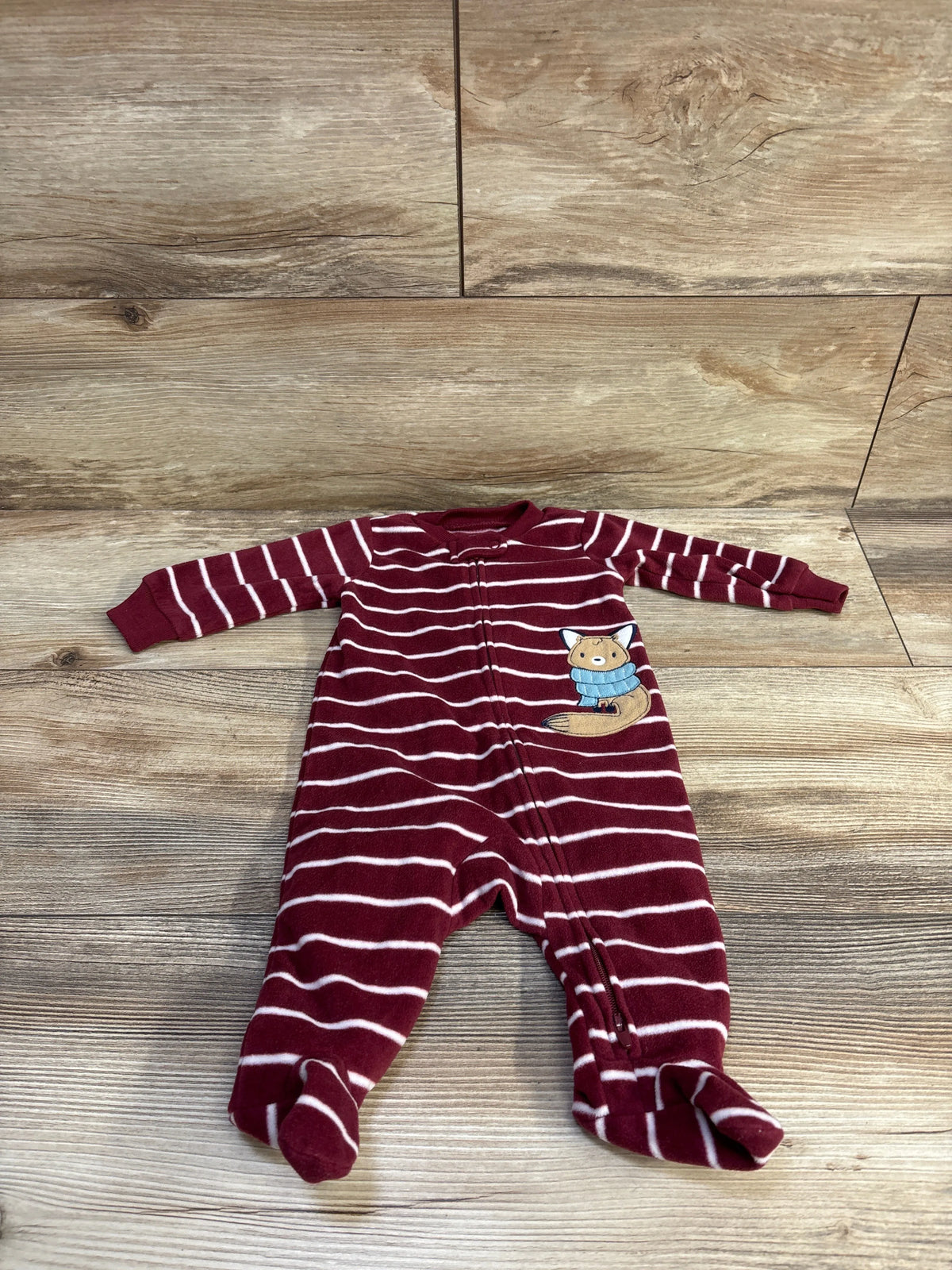 Front flat lay of Carter’s maroon-and-white striped blanket sleeper with zipper, footed legs, and fox patch on wooden floor