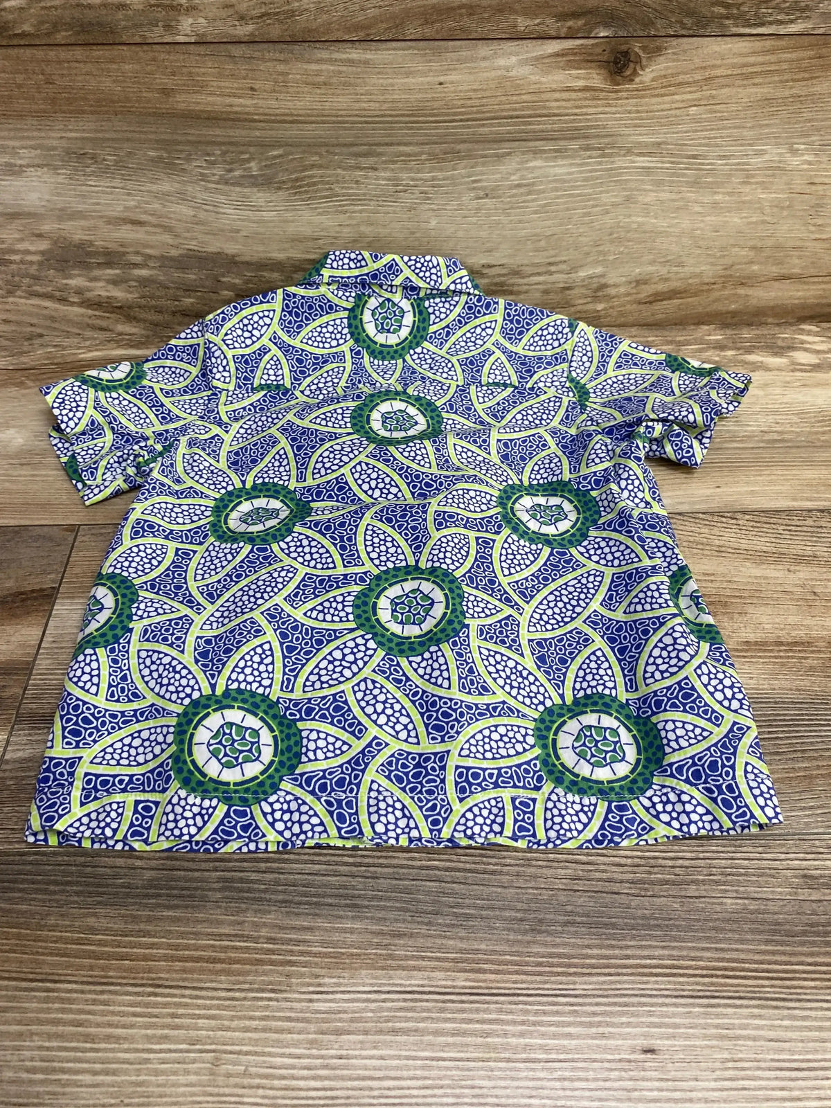 Back view of Janie and Jack toddler button-up shirt size 2T showcasing blue, green, and white circular floral print on wood background