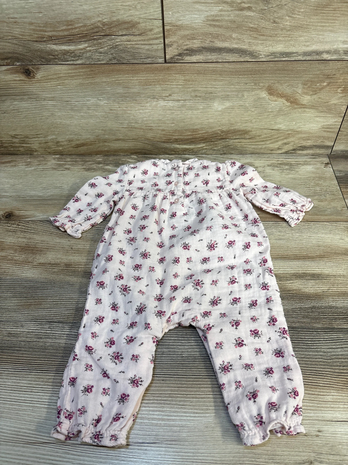 Pink floral long sleeve baby romper on wood background, gently used kids clothing