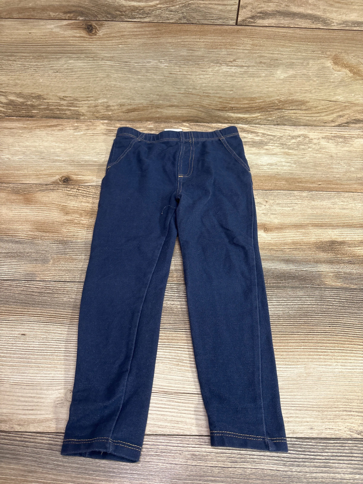 Front view of Koala Kids navy jeggings in size 4T showcasing an elastic waistband and contrast stitching on a wood-grain background