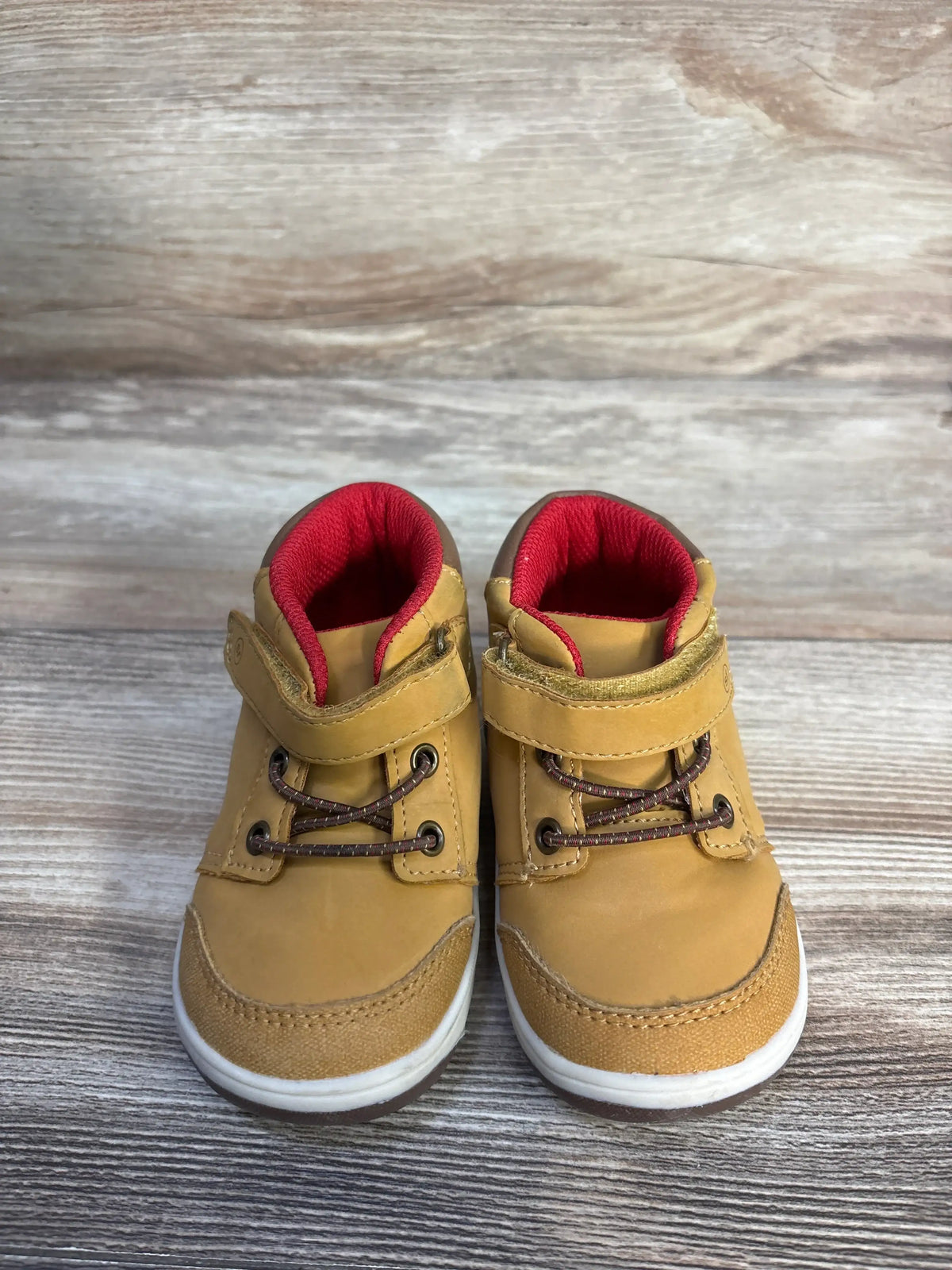 Front view of Stride Rite 360 Indiana Honey Yellow sneaker boots showcasing hook and loop closures on a wood surface