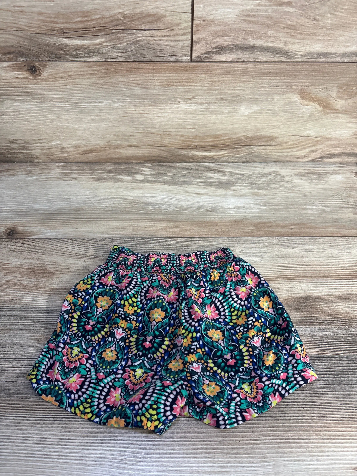 Front view of Old Navy navy rayon pattern shorts showcasing the colorful floral pattern and relaxed fit on a wood background