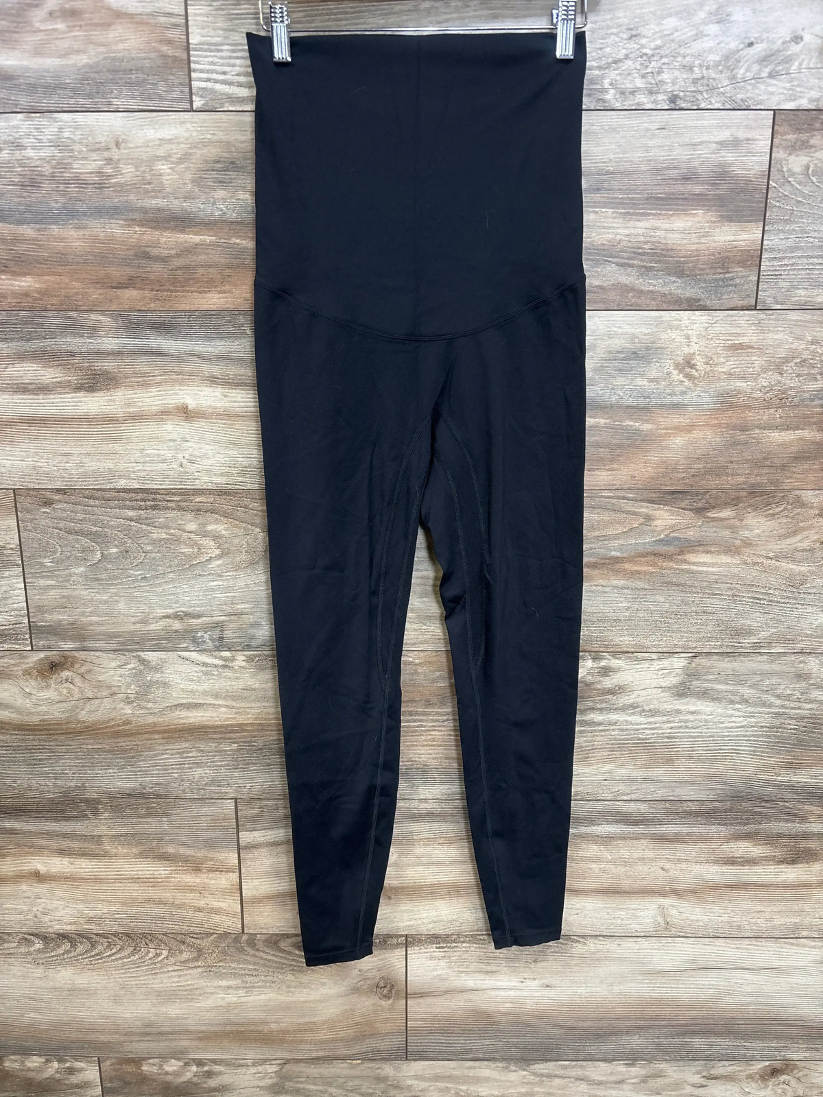 Front view of Poshdivah black full panel leggings showcasing the over-belly panel and fitted legs on a wood-look floor