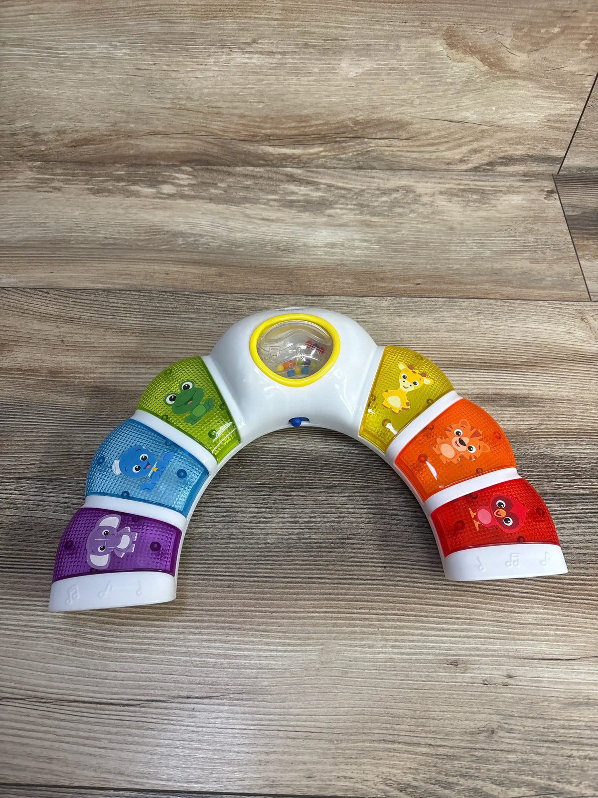 Colorful rainbow baby musical toy keyboard with animal faces on wood floor