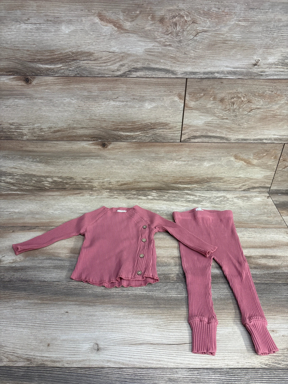 Flat lay of Mud Pie 2pc rose ribbed knit kimono shirt with side button closure and matching leggings on wood plank floor