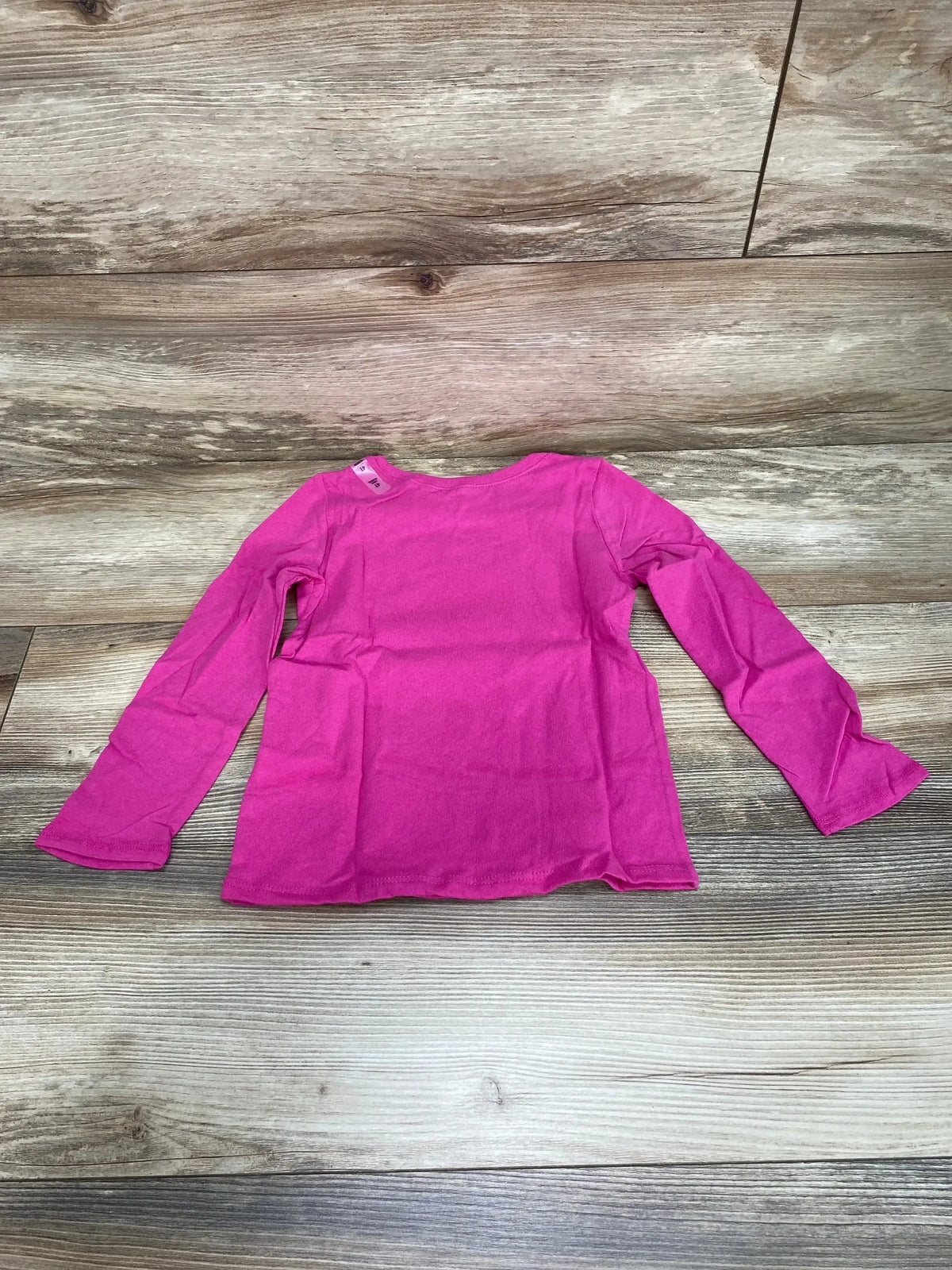 Back view of Children's Place long-sleeve pink toddler shirt size 4T showing plain back and crew neckline on wood floor