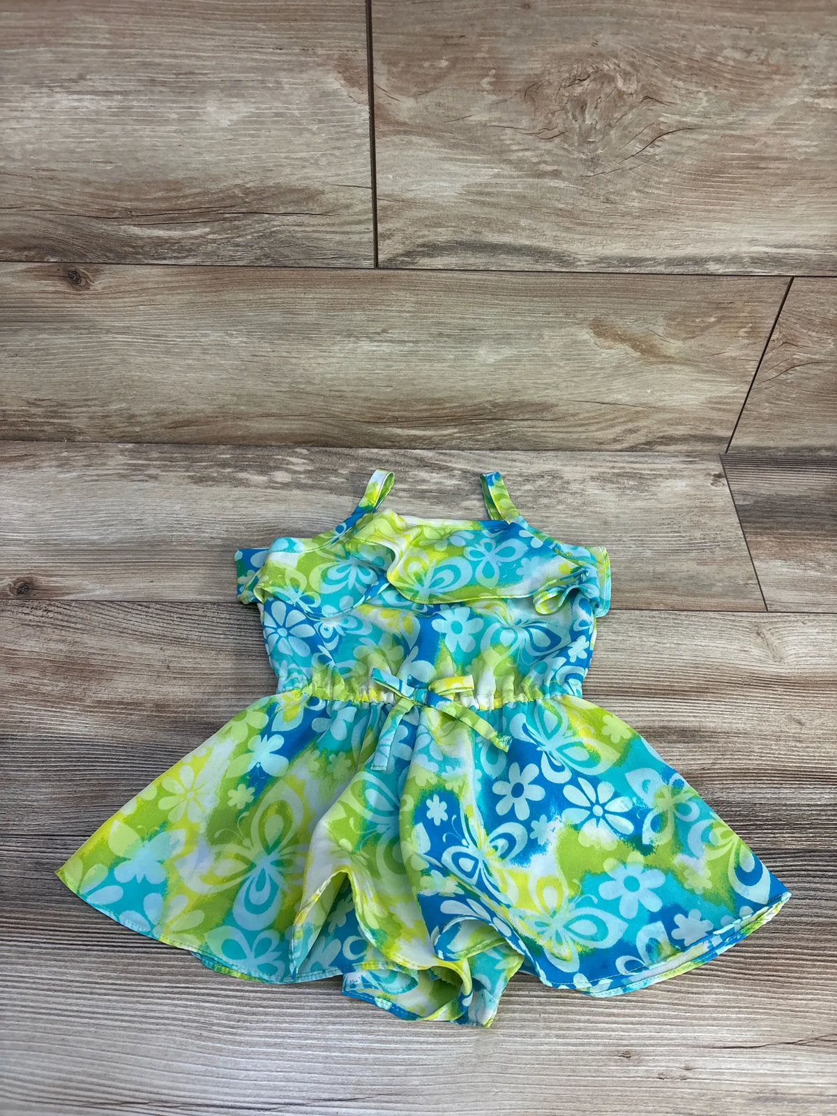 Front view of Youngland teal swim cover-up romper in size 2T showcasing floral print and skirt overlay on wood flooring