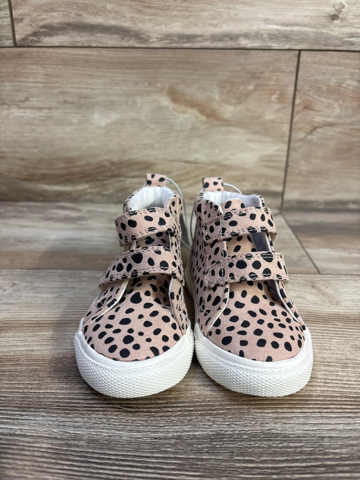Front view of toddler Cat & Jack high-top sneakers showing beige leopard print, two Velcro straps and white rubber soles on wood floor