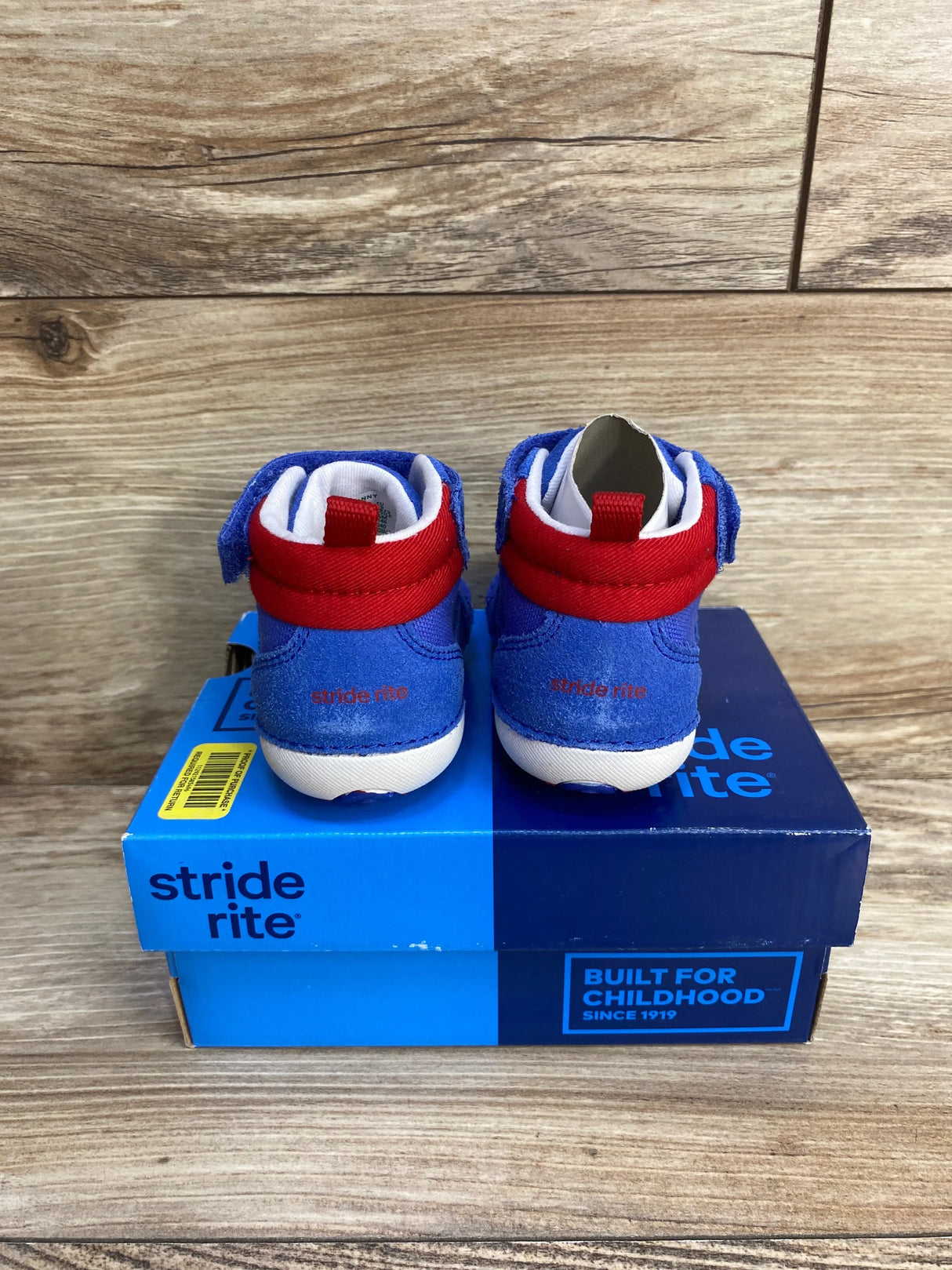 Rear view of Stride Rite Danny toddler sneakers, blue suede with red ankle strap and white soles on blue box