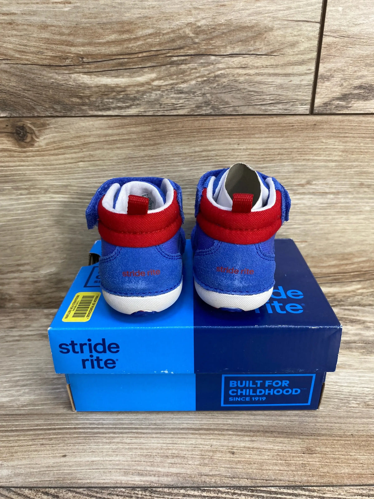 Rear view of Stride Rite Danny toddler sneakers, blue suede with red ankle strap and white soles on blue box