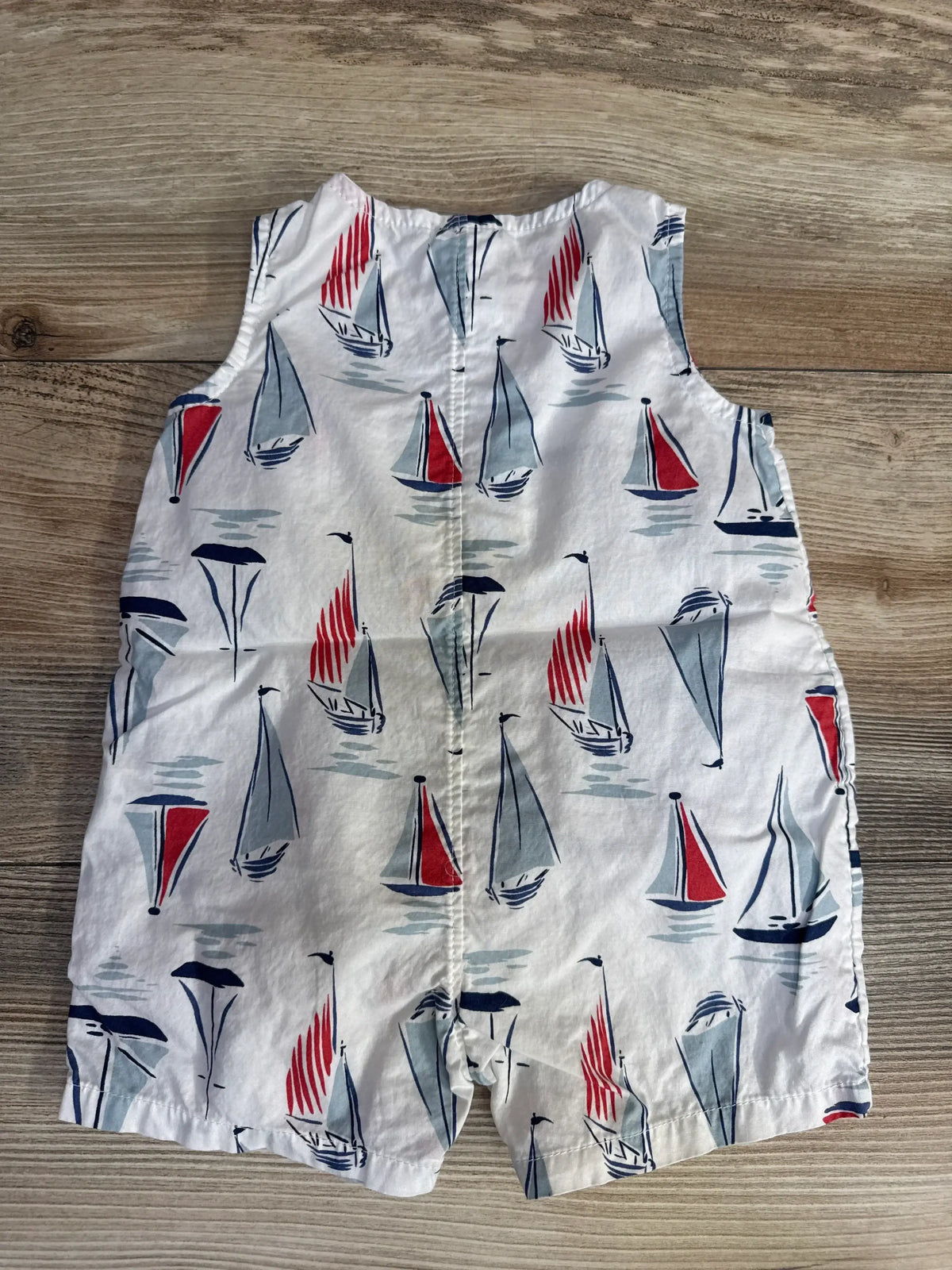 Front view of Just One You sailboat tank romper, size 3 months, with red, navy, and gray print on wood floor