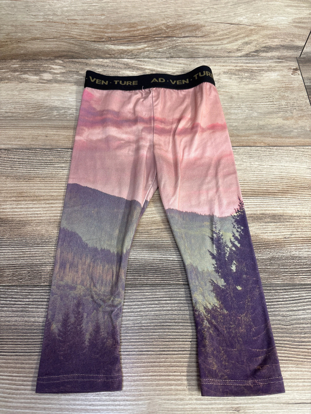 Kids leggings with sunset mountain forest print and ADVENTURE waistband on wooden background