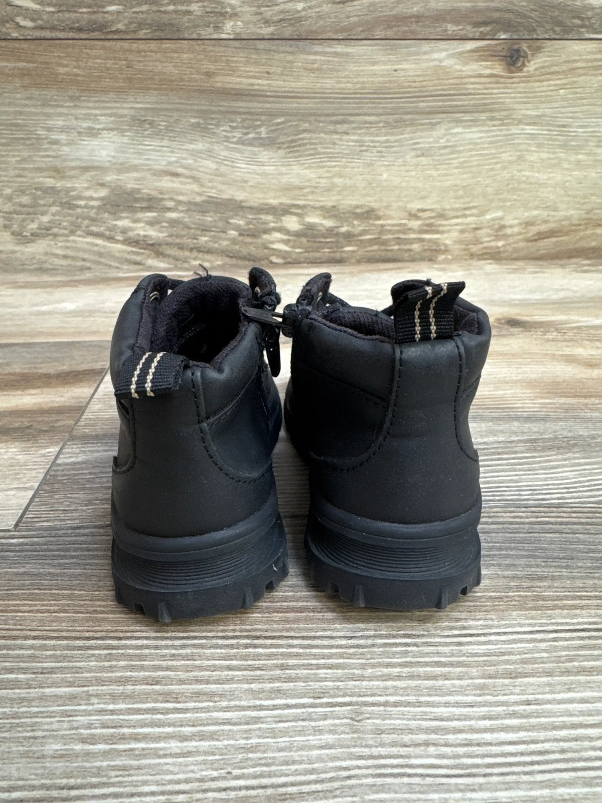 Rear view of Zara boy's side-zip boots size 7C showcasing pull tabs, side zipper pull, and chunky treaded soles on wood floor