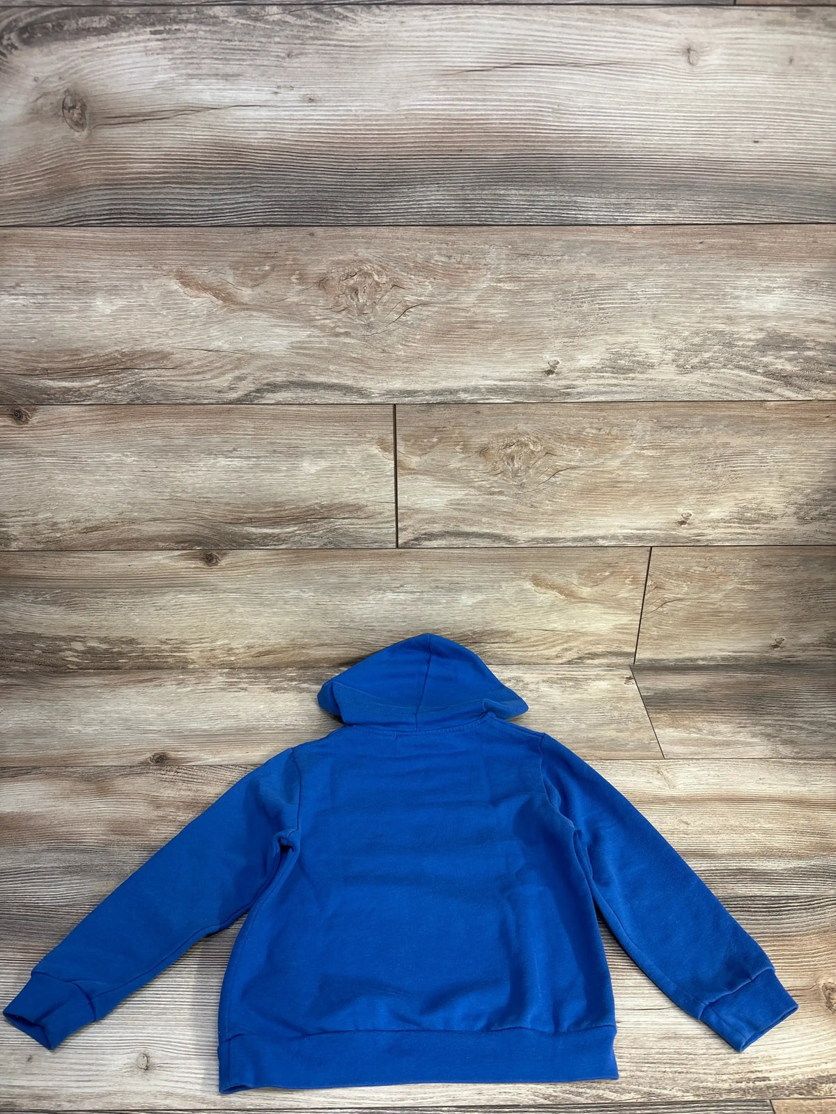 Back view of toddler blue Super Mario Luigi pullover hoodie size 4/5T laid flat on wood background