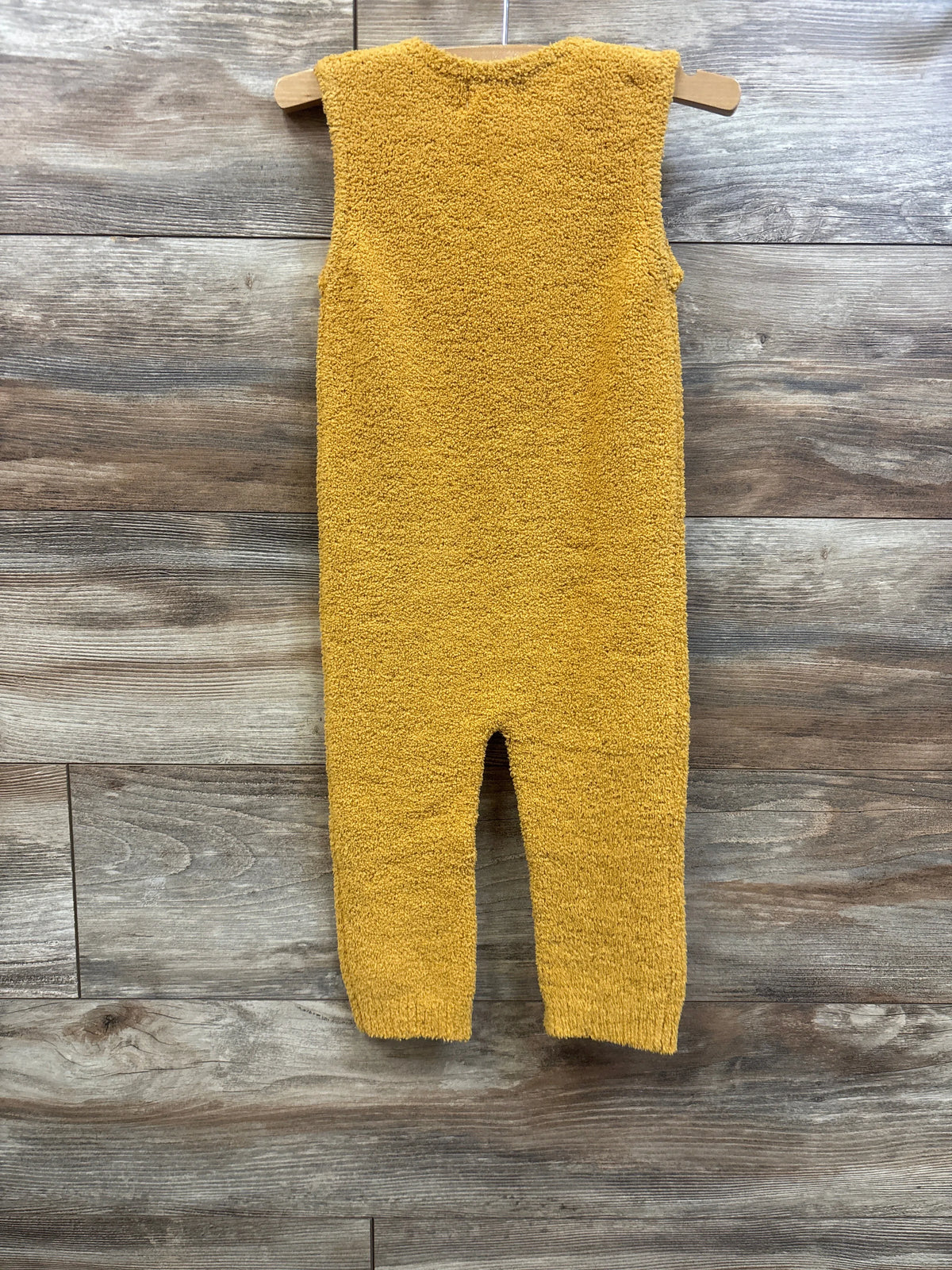 Amber yellow fuzzy sleeveless jumpsuit for babies by Me n Mommy To Be on a wooden background