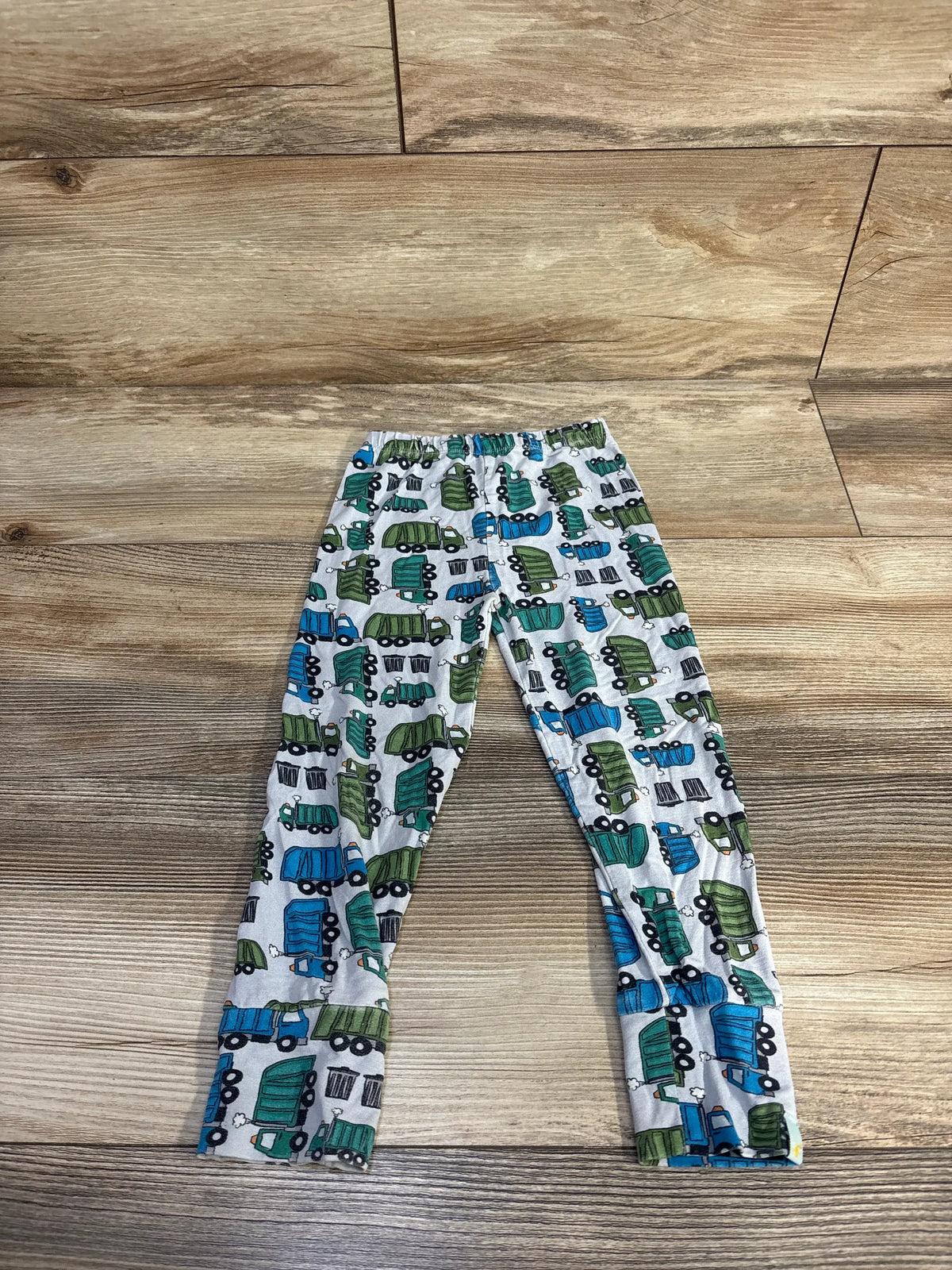Front view of Clover Baby & Kids blue viscose pants showcasing elastic waistband and dump truck print on wood floor