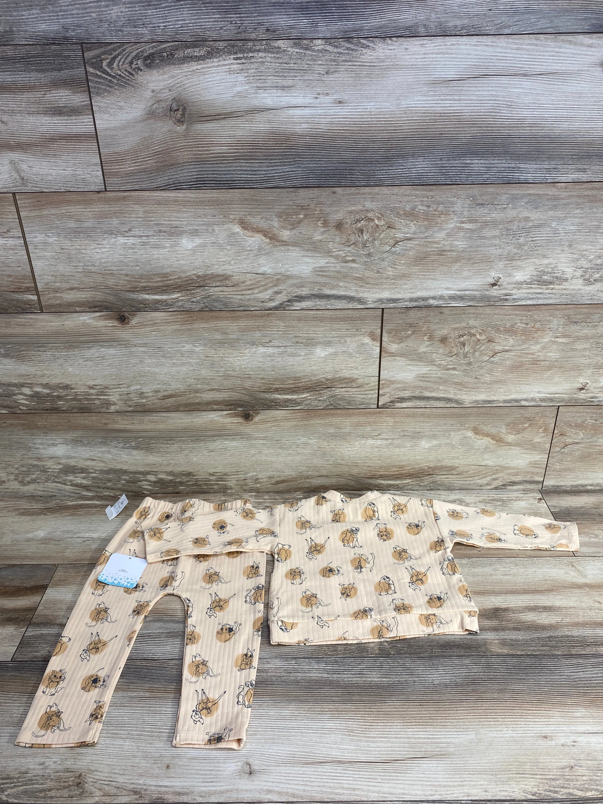 Beige ribbed baby outfit with long sleeves and pants featuring playful cartoon animal prints