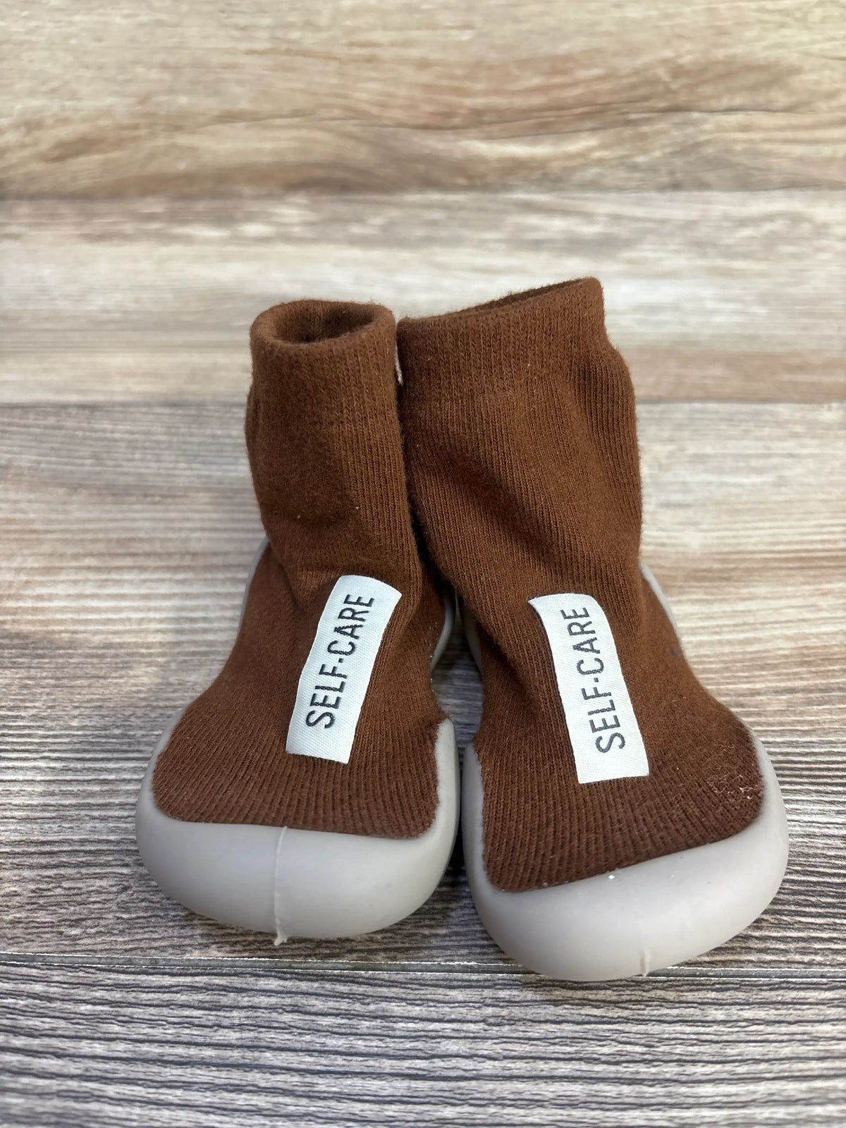 Front view of Tiny Explorings Self-Care Sock Shoes, brown size 2/3C, showing sock-style uppers and white soles
