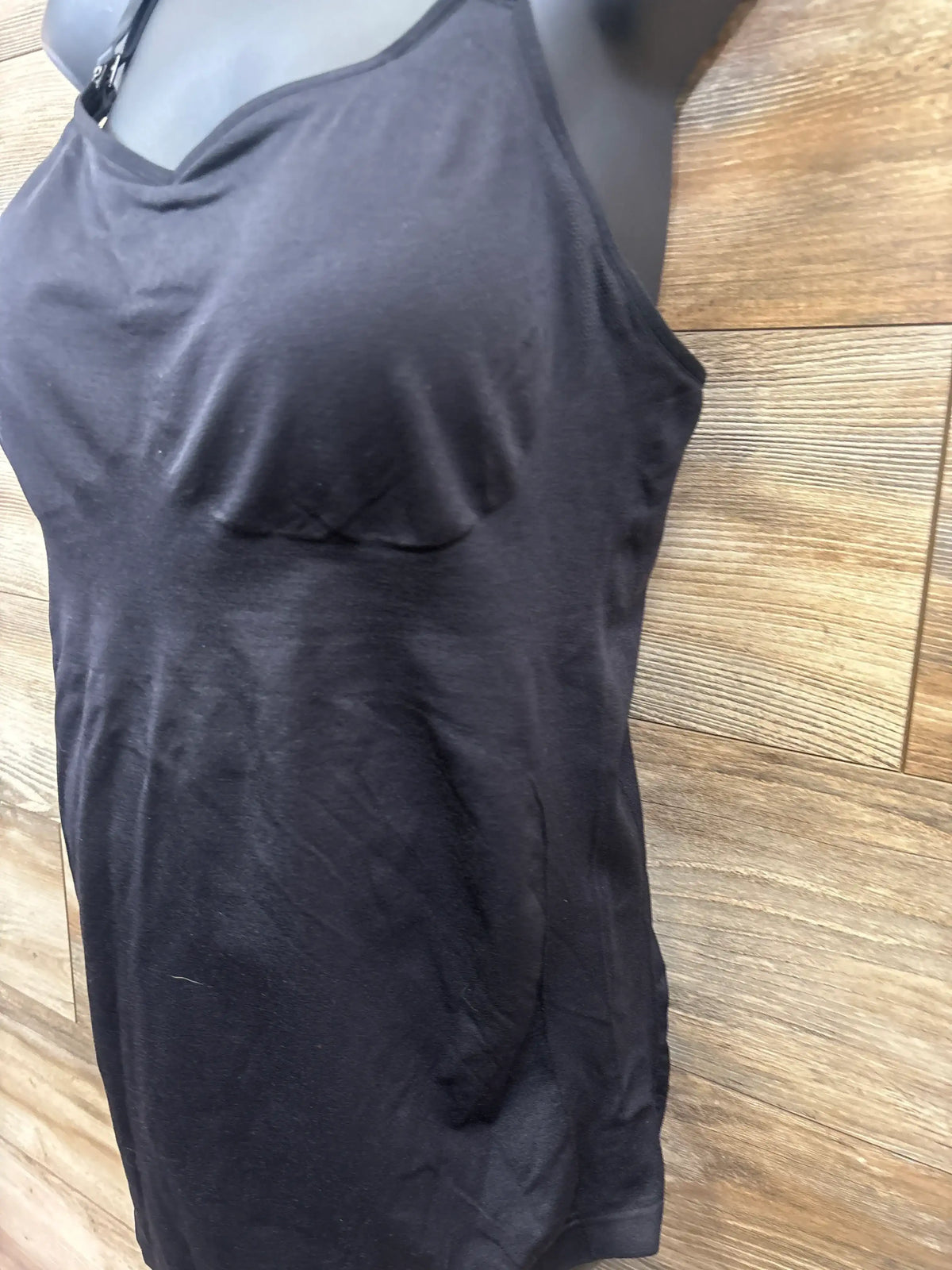 Black sleeveless maternity tank top on mannequin against wood background