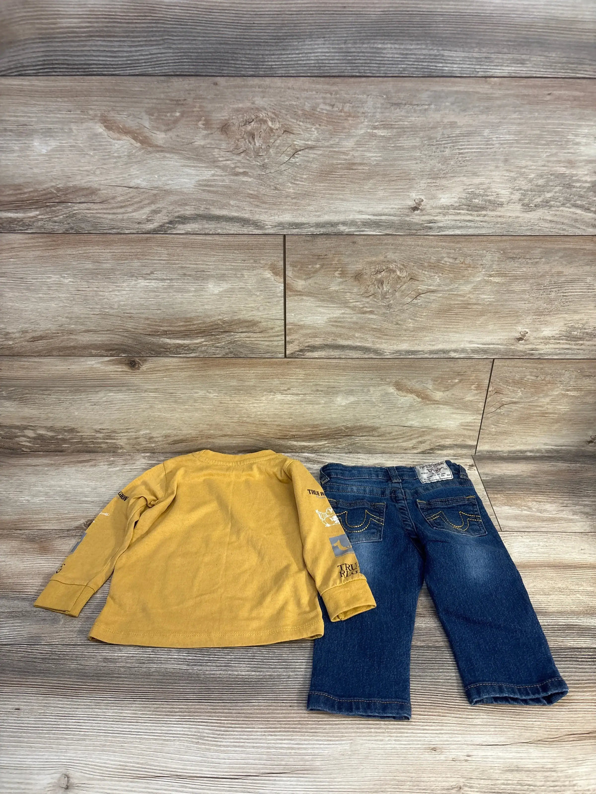 Yellow long sleeve kids shirt and blue jeans set on wood floor, kids clothing resale