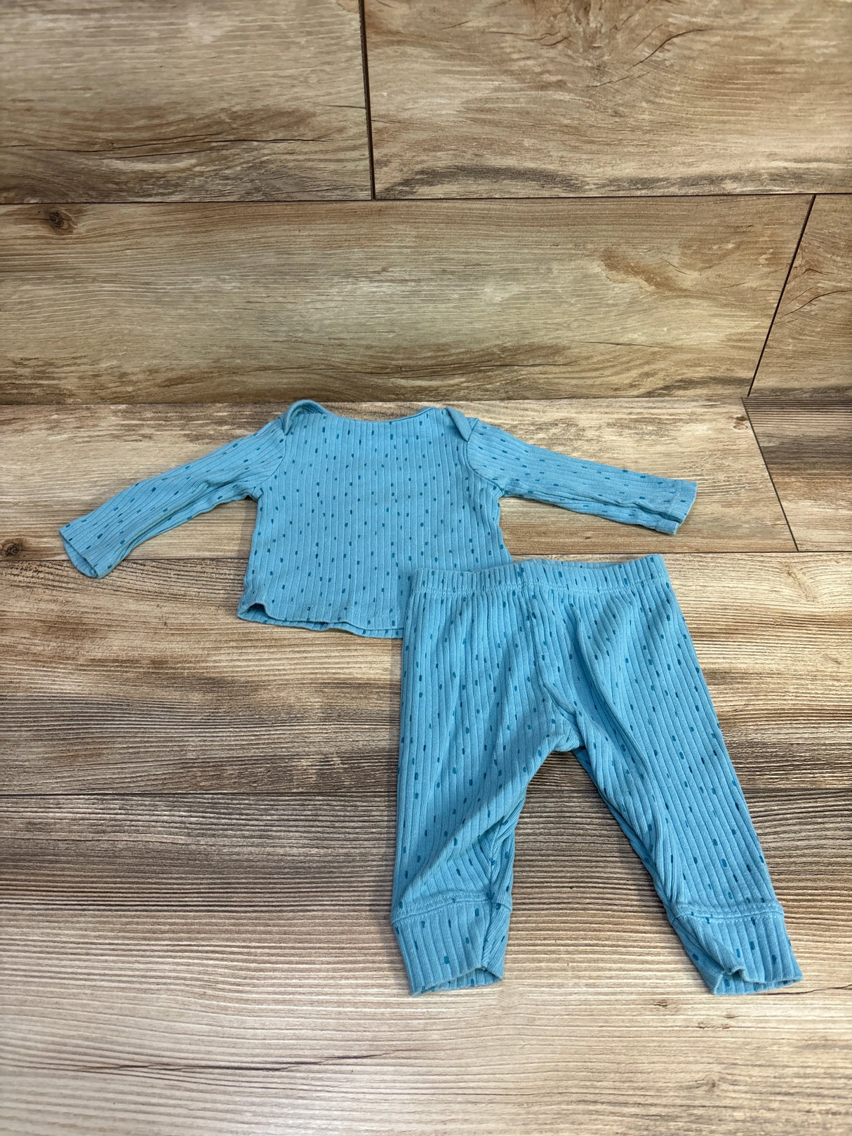 Flat lay of Cloud Island ribbed 2-piece baby set size 0-3M with long-sleeve top and cuffed elastic-waist pants on wood background