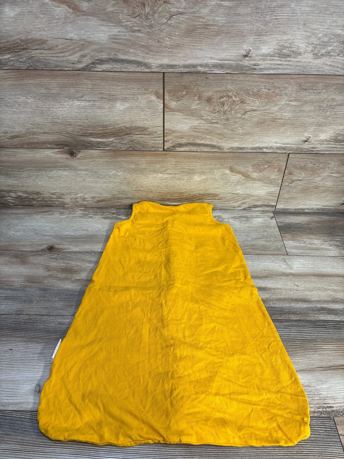 Back view of Tillyou elephant sleep sack in soft yellow laid flat on wood flooring