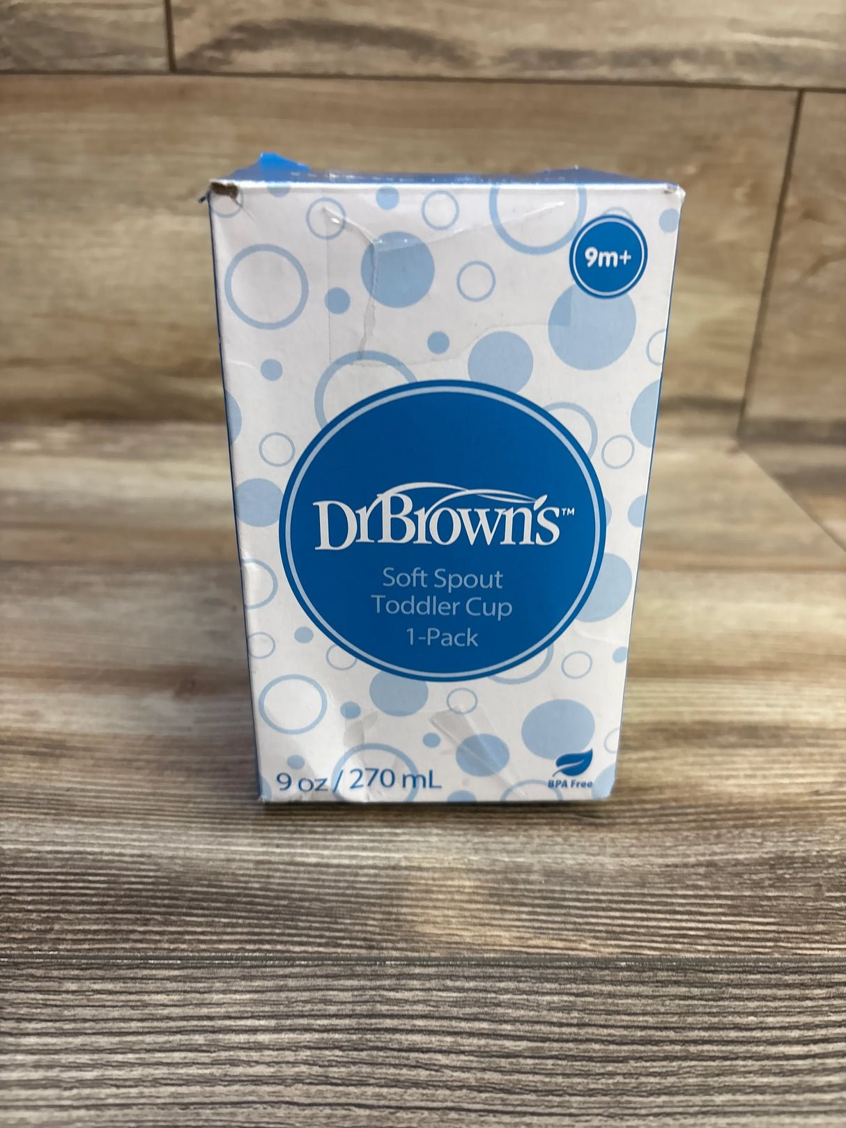 Front view of Dr. Brown’s Soft Spout Toddler Cup box showing blue logo, 1-Pack label and 9 oz / 270 mL text on wood tabletop